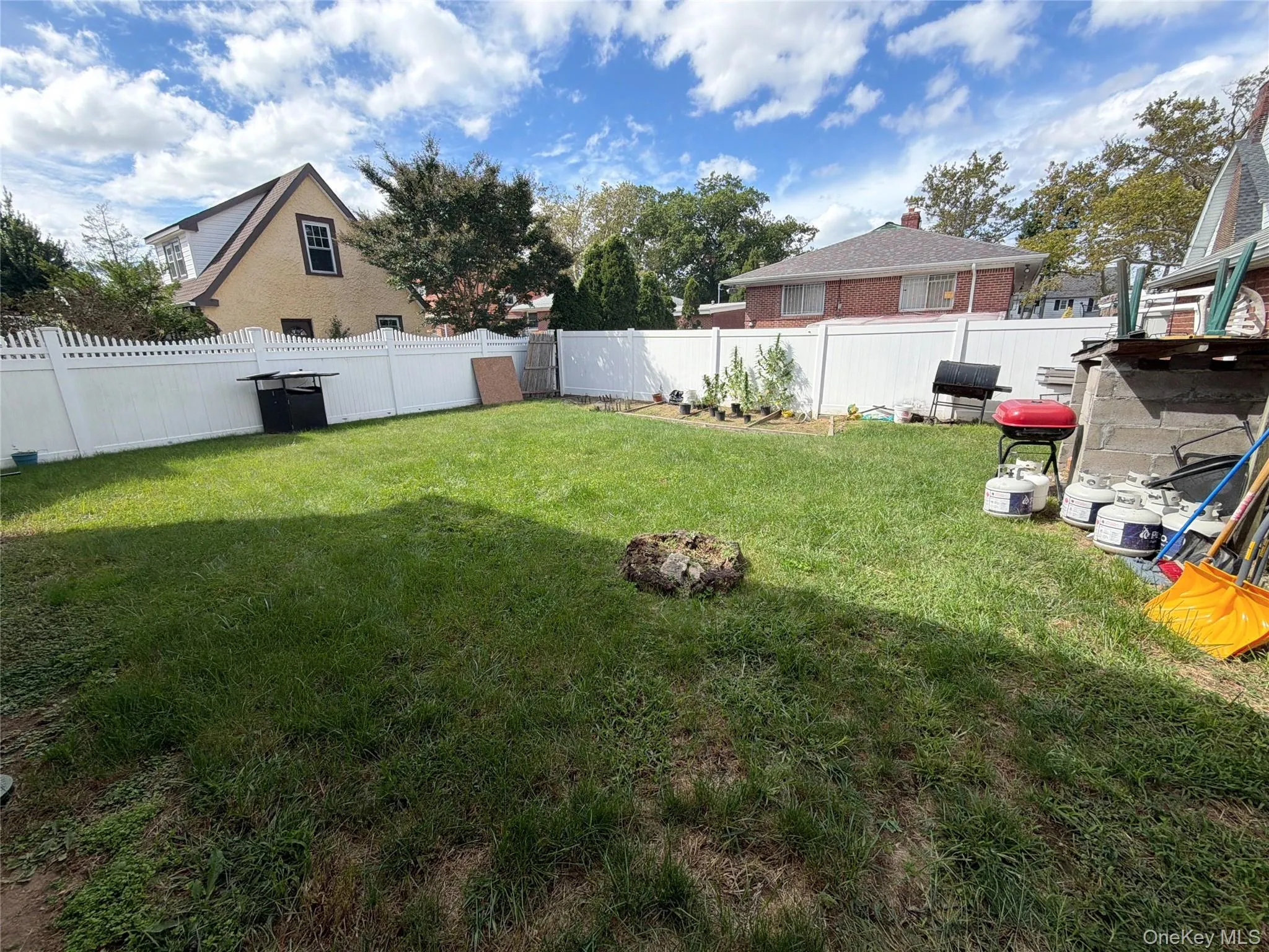 Expansive grassy yard with white privacy fencing Expansive grassy yard with white privacy fencing