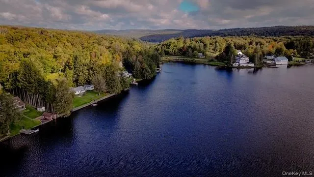 Lakefront property with direct water access, dense tree coverage, and a mountainous backdrop Lakefront property with direct water access, dense tree coverage, and a mountainous backdrop