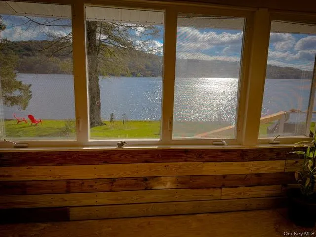 Expansive windows offering water frontage, wood-paneled interior walls, and a wood-finish floor Expansive windows offering water frontage, wood-paneled interior walls, and a wood-finish floor