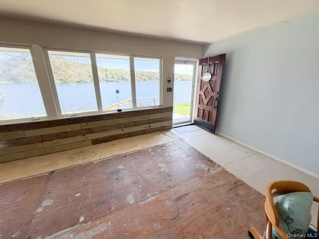 Multiple large windows, wood plank wainscoting, light blue painted walls, and a substantial wooden entry door Multiple large windows, wood plank wainscoting, light blue painted walls, and a substantial wooden entry door