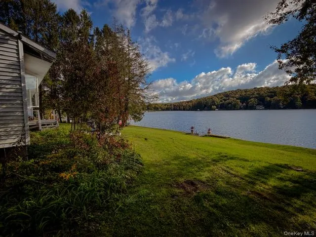 Expansive waterfront lawn featuring mature trees and established landscaping Expansive waterfront lawn featuring mature trees and established landscaping