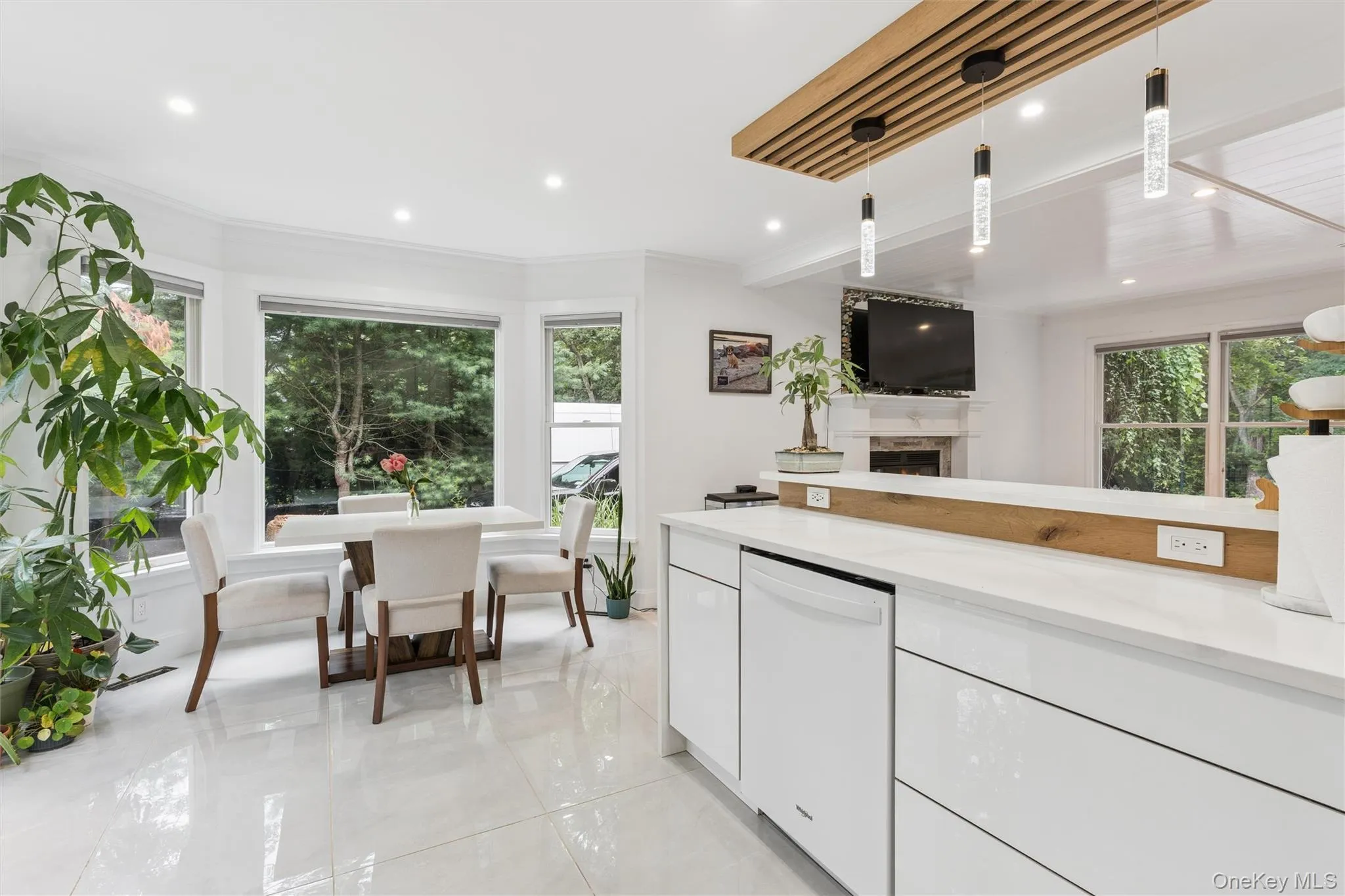 White tile flooring, bay window, recessed lighting, and a modern kitchen island with an integrated dishwasher White tile flooring, bay window, recessed lighting, and a modern kitchen island with an integrated dishwasher