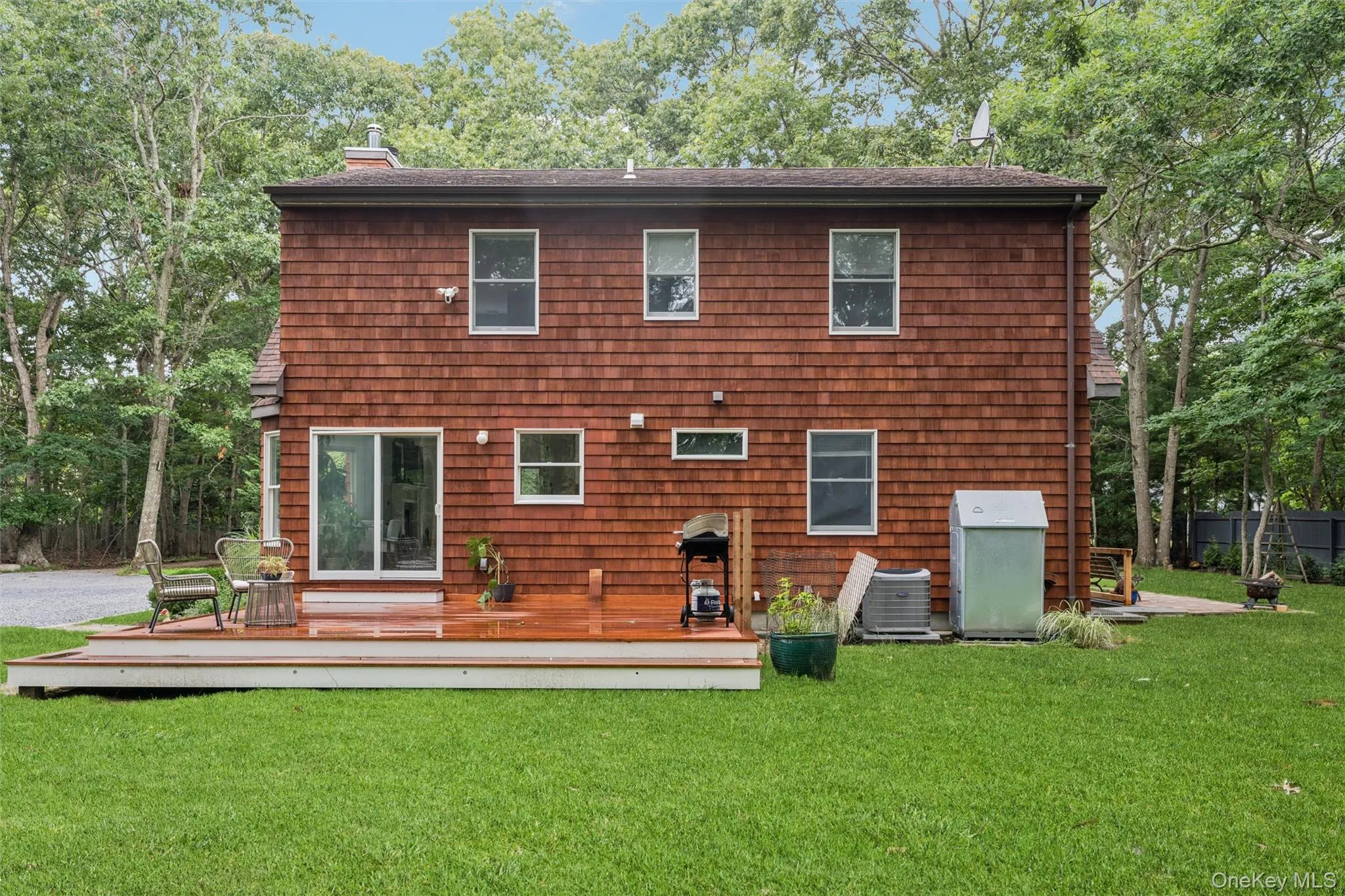 Wood-shingle exterior with multiple windows and a sliding glass door Wood-shingle exterior with multiple windows and a sliding glass door