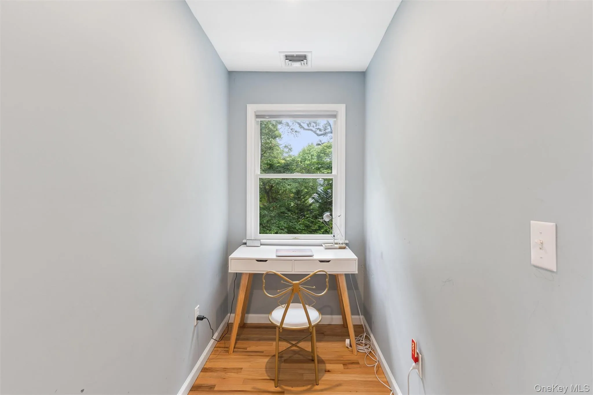 Windowed alcove featuring wood-finish flooring and light-toned walls Windowed alcove featuring wood-finish flooring and light-toned walls