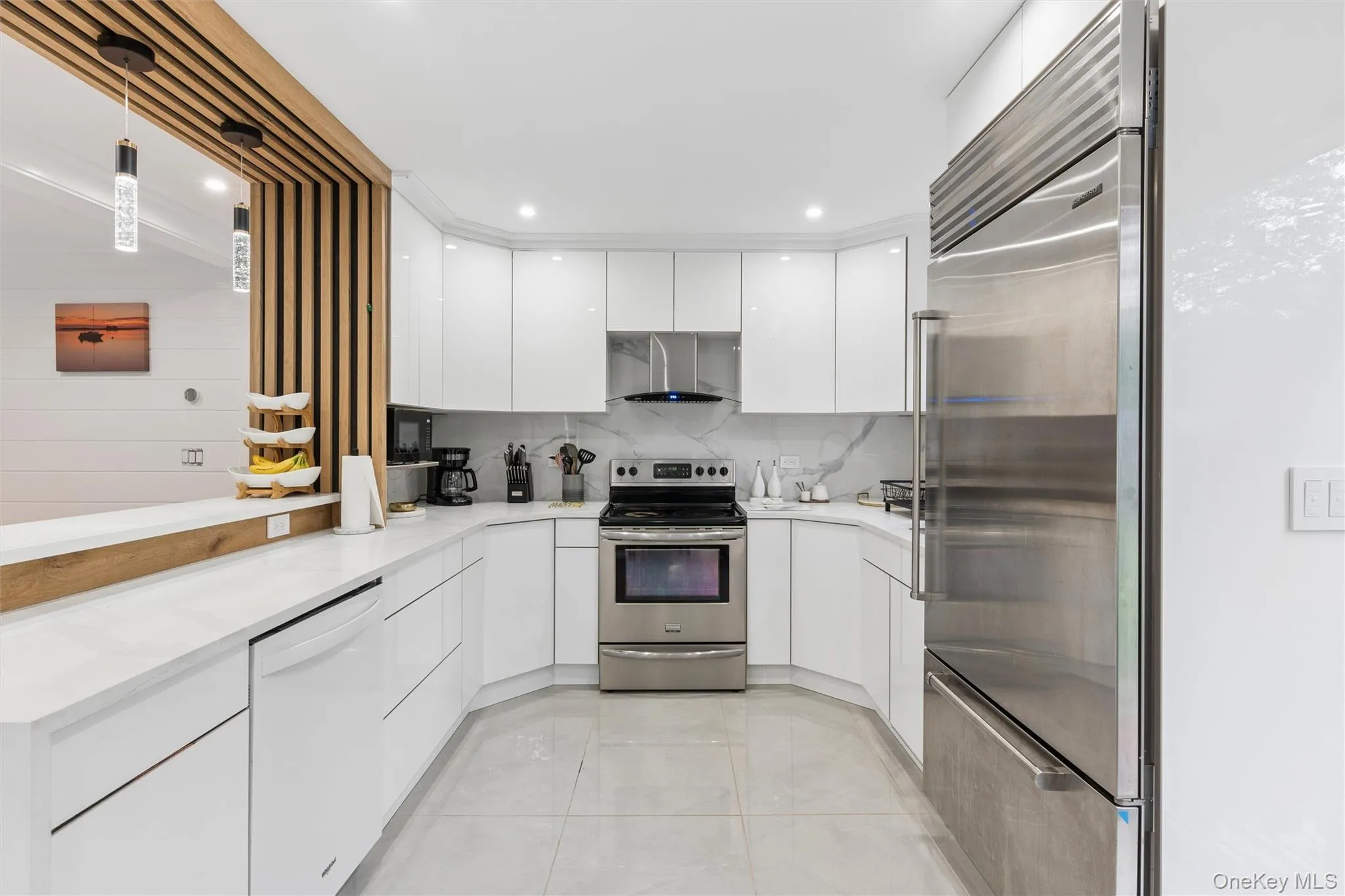 Modern kitchen featuring white glossy cabinetry, stainless steel appliances, a white countertop, and recessed lighting Modern kitchen featuring white glossy cabinetry, stainless steel appliances, a white countertop, and recessed lighting