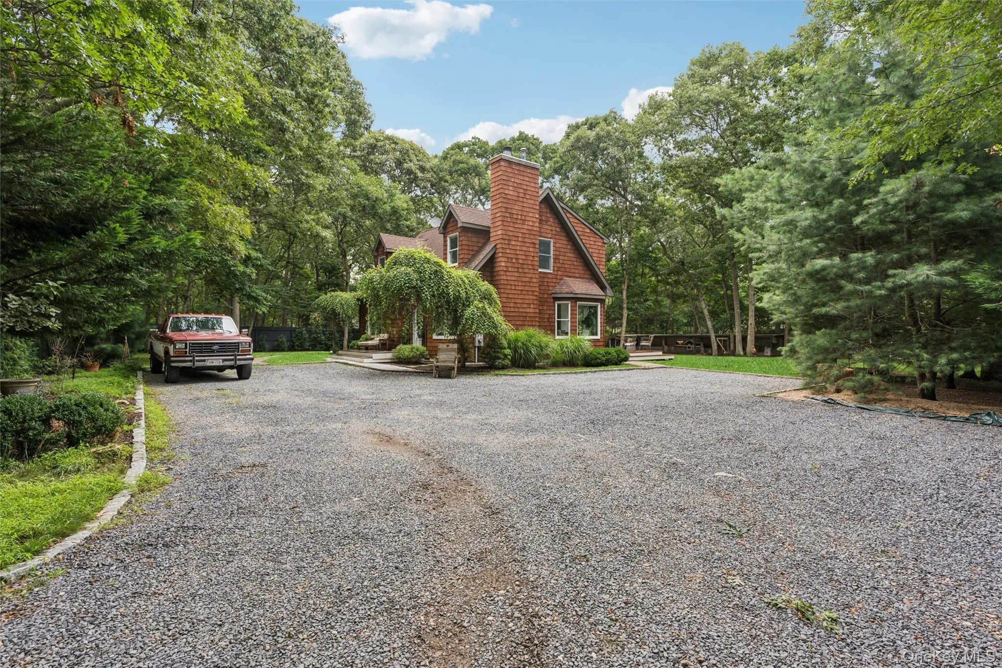 Wood-shingle exterior featuring a prominent chimney and bay window Wood-shingle exterior featuring a prominent chimney and bay window