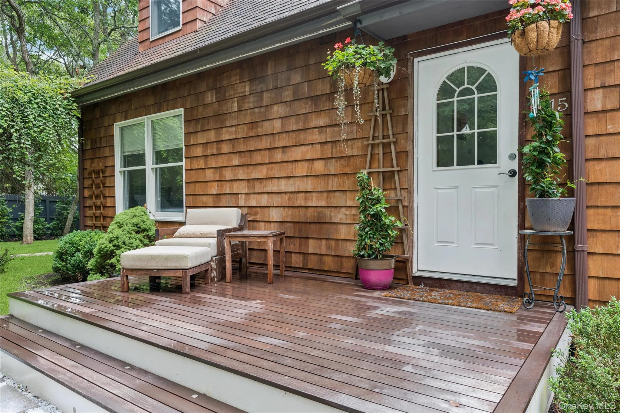 Wood-shingle exterior with a white entry door featuring an arched window Wood-shingle exterior with a white entry door featuring an arched window