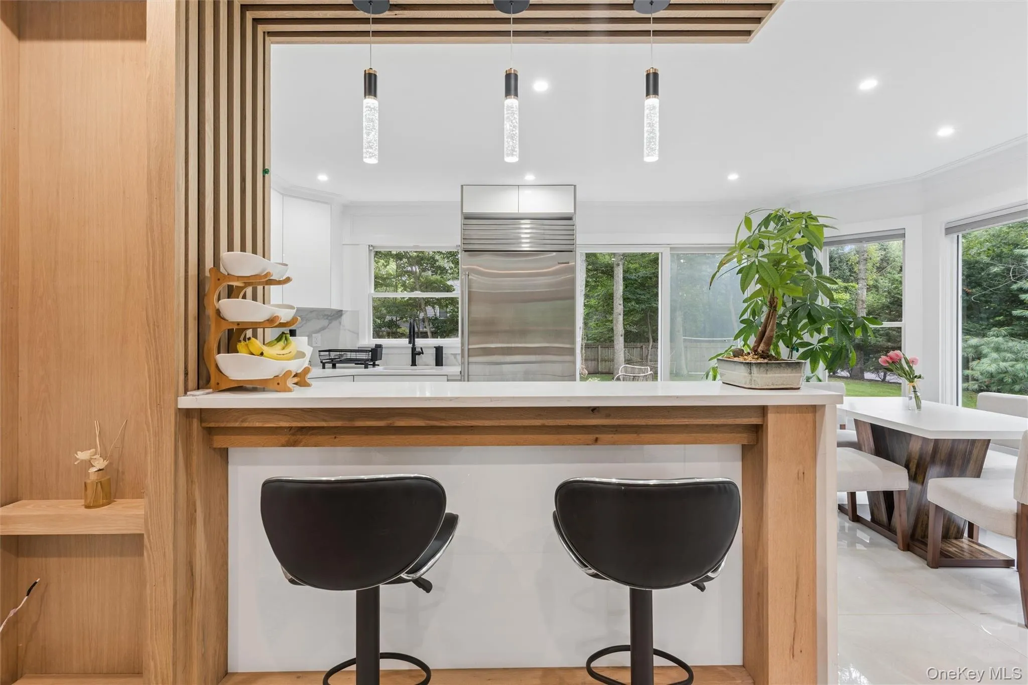 Kitchen pass-through featuring a wood-finish bar and white countertop Kitchen pass-through featuring a wood-finish bar and white countertop