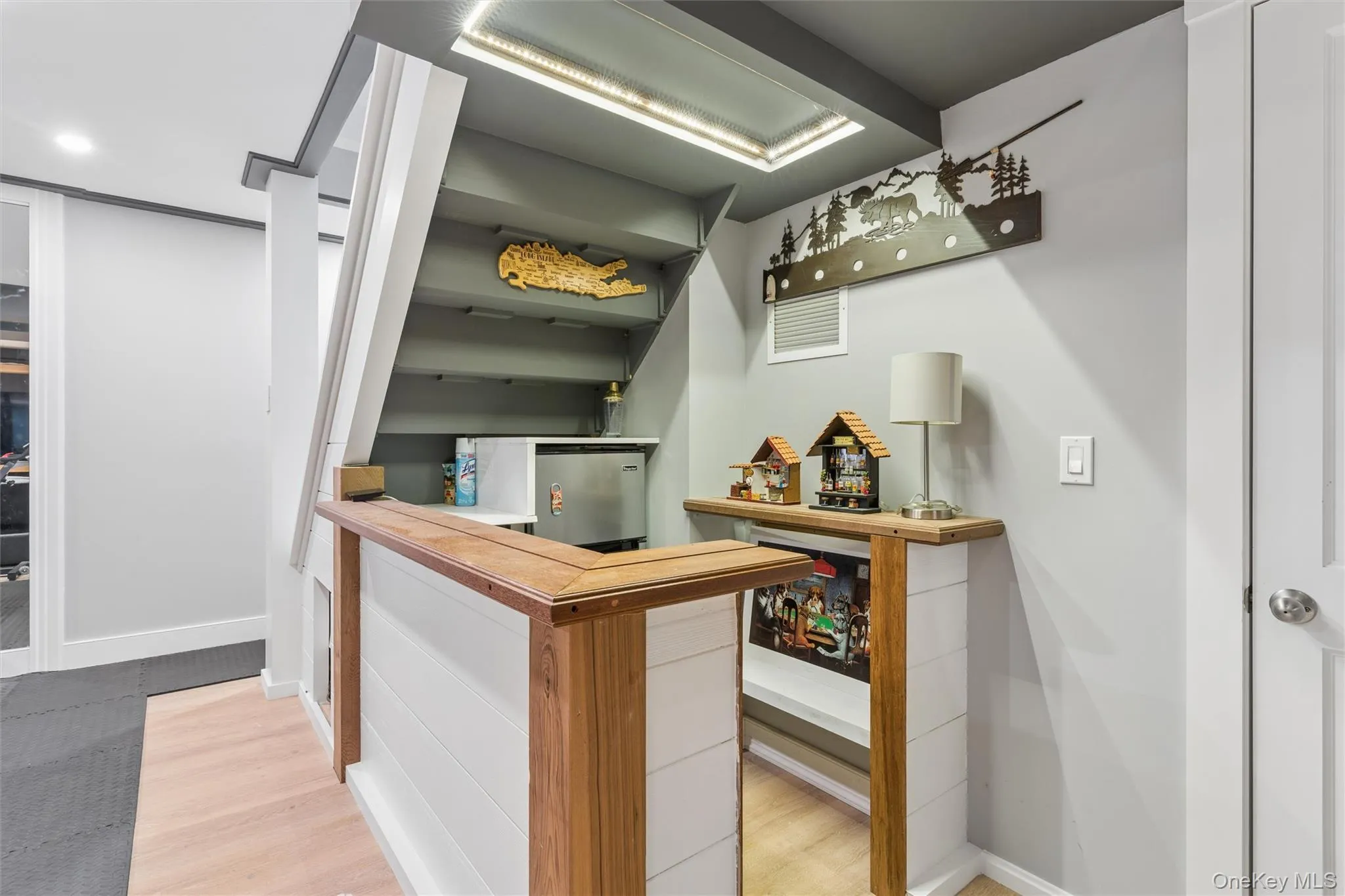 Custom bar featuring a wood-finish countertop, shiplap paneling, and a compact refrigerator Custom bar featuring a wood-finish countertop, shiplap paneling, and a compact refrigerator