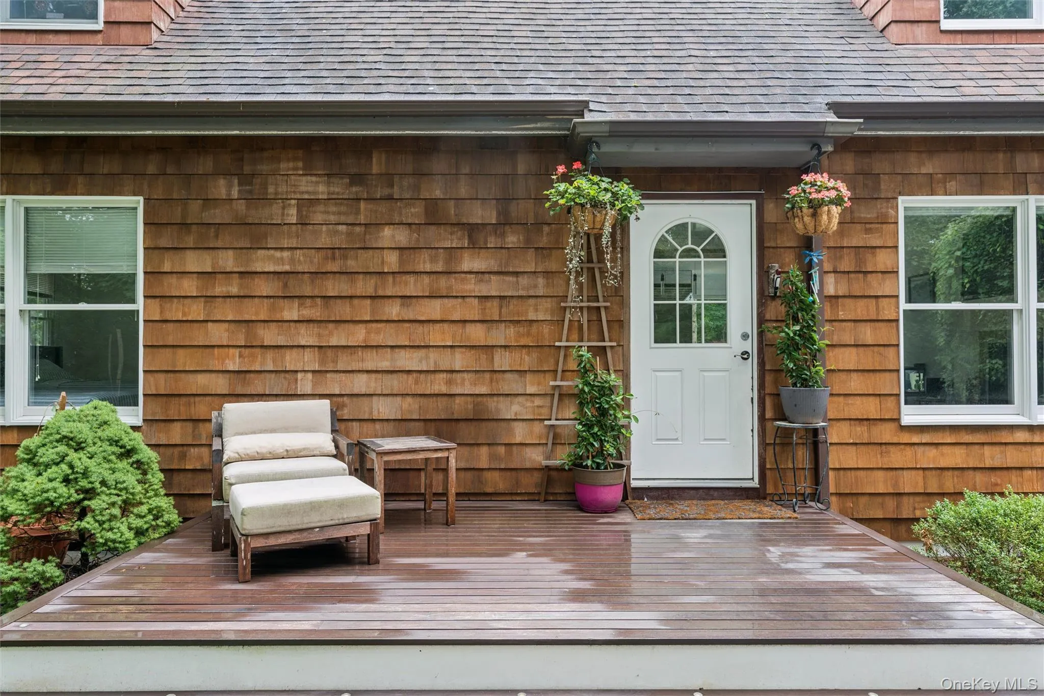 Wood-shingle exterior with white trim windows and a white arched-pane door Wood-shingle exterior with white trim windows and a white arched-pane door