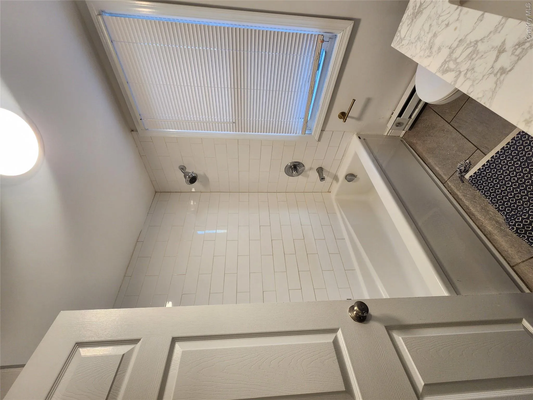 Full bath with shower / washtub combination, tile patterned flooring, and a baseboard heating unit Full bath with shower / washtub combination, tile patterned flooring, and a baseboard heating unit