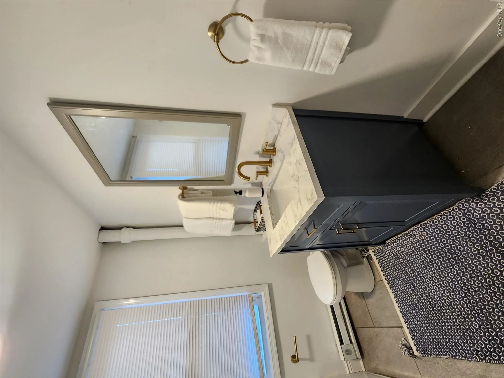 Half bathroom with a baseboard heating unit, vanity, and tile patterned floors Half bathroom with a baseboard heating unit, vanity, and tile patterned floors