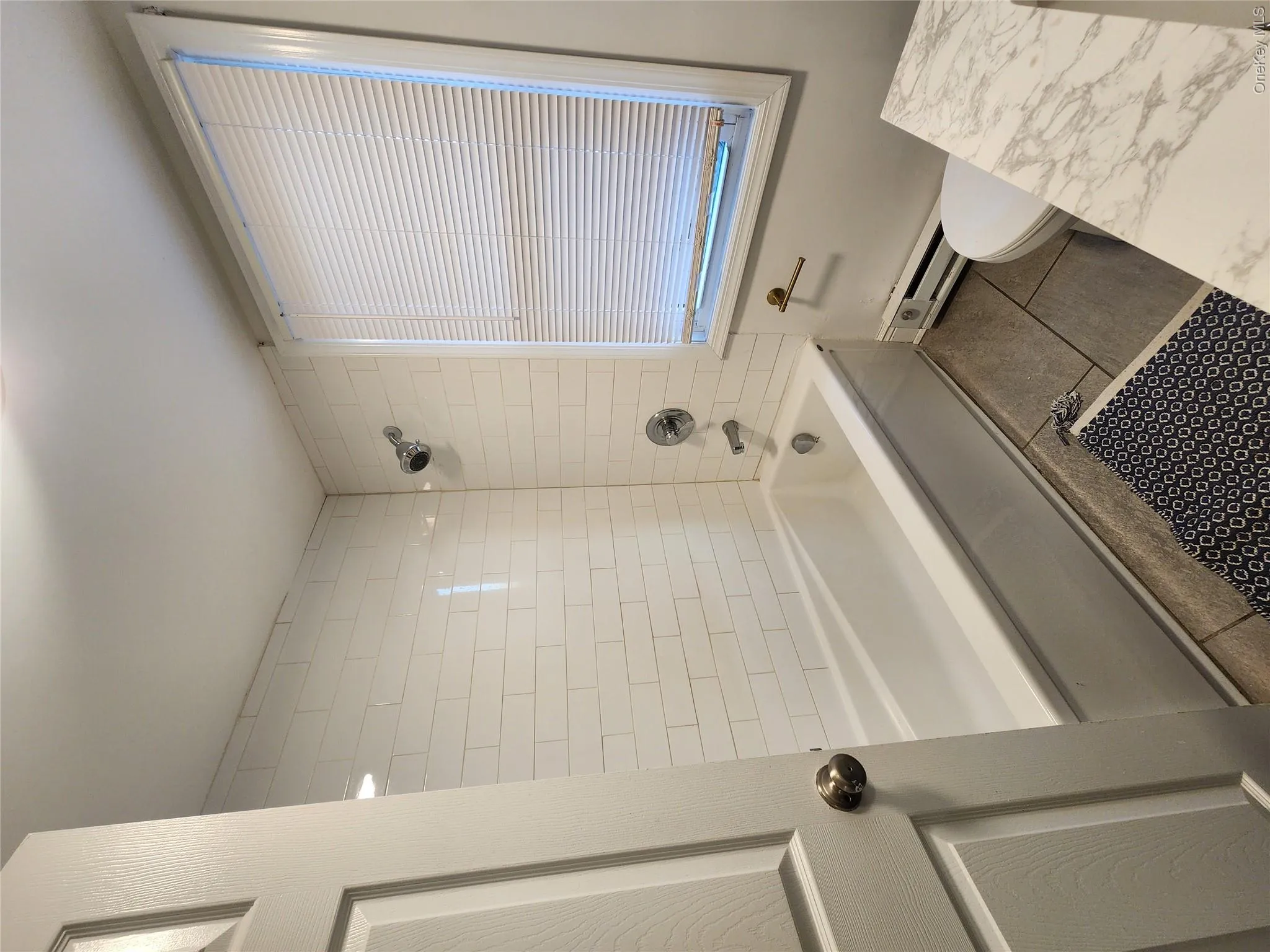 Full bath with shower combination, baseboard heating, and tile patterned flooring Full bath with shower combination, baseboard heating, and tile patterned flooring