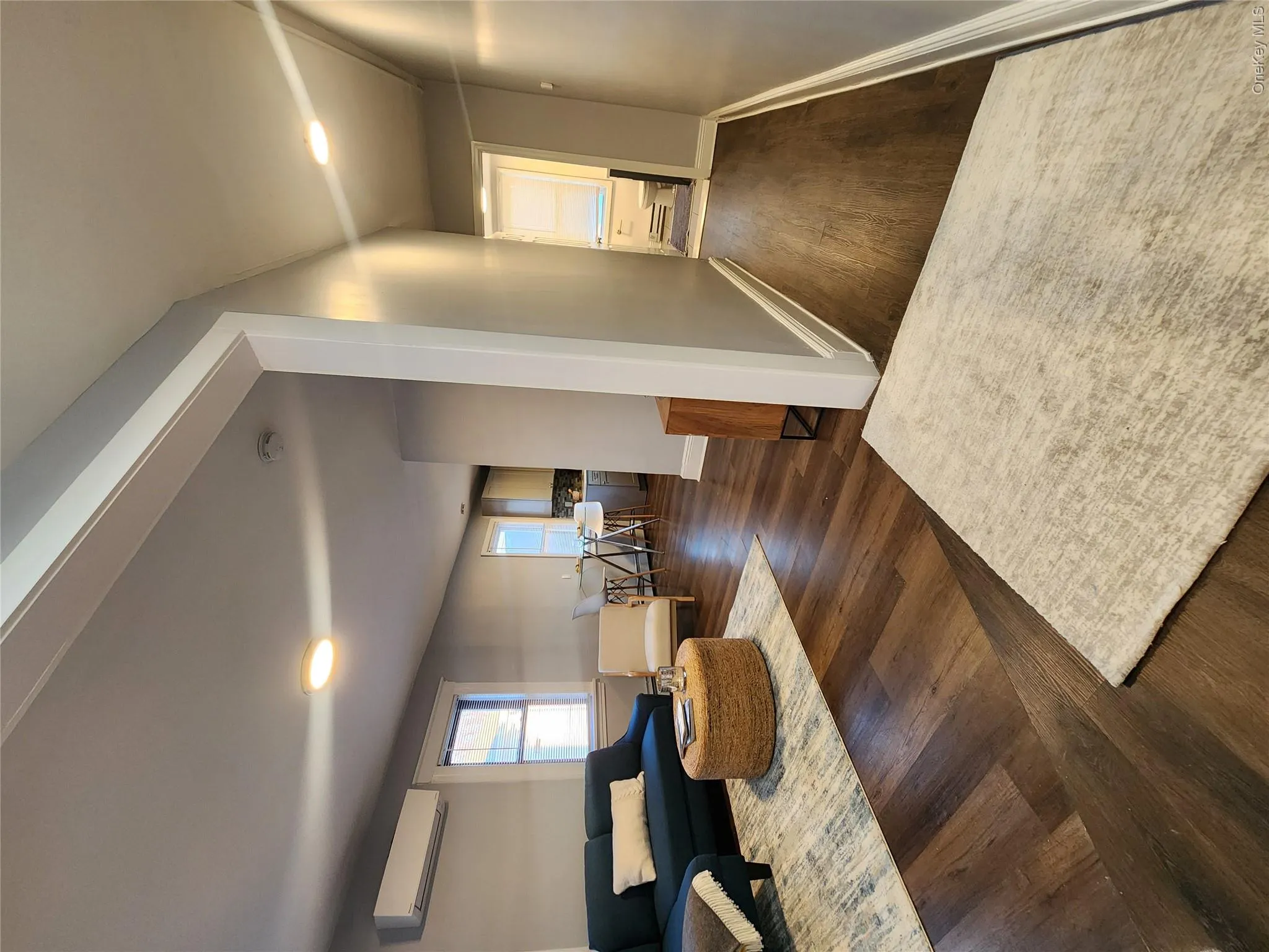 Corridor featuring wood finished floors and a wall mounted air conditioner Corridor featuring wood finished floors and a wall mounted air conditioner