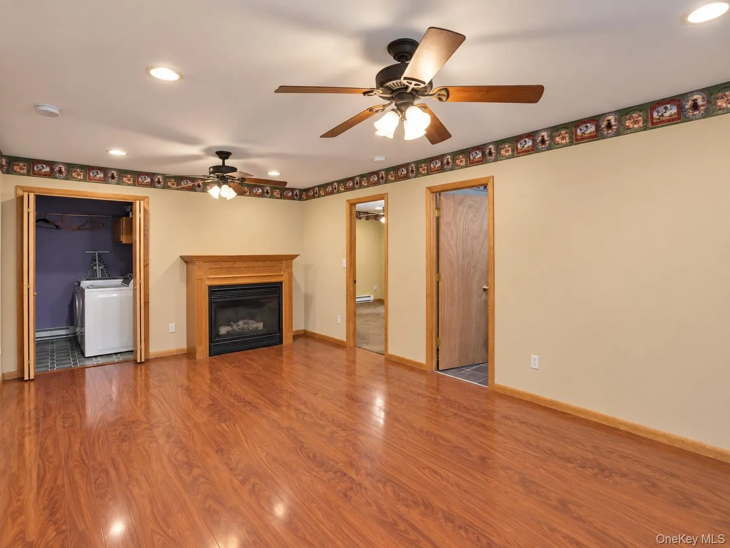 Wood-finish flooring, recessed lighting, ceiling fans, and a propane fireplace with a wood-finish mantel Wood-finish flooring, recessed lighting, ceiling fans, and a propane fireplace with a wood-finish mantel