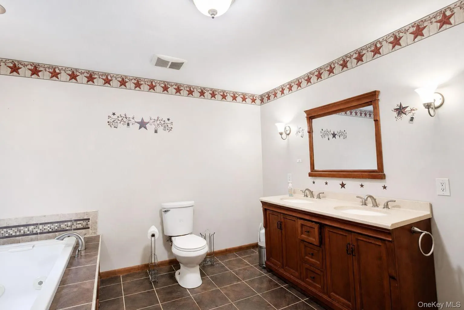 Dual vanity with wood-finish cabinetry, integrated sinks, and polished chrome fixtures Dual vanity with wood-finish cabinetry, integrated sinks, and polished chrome fixtures