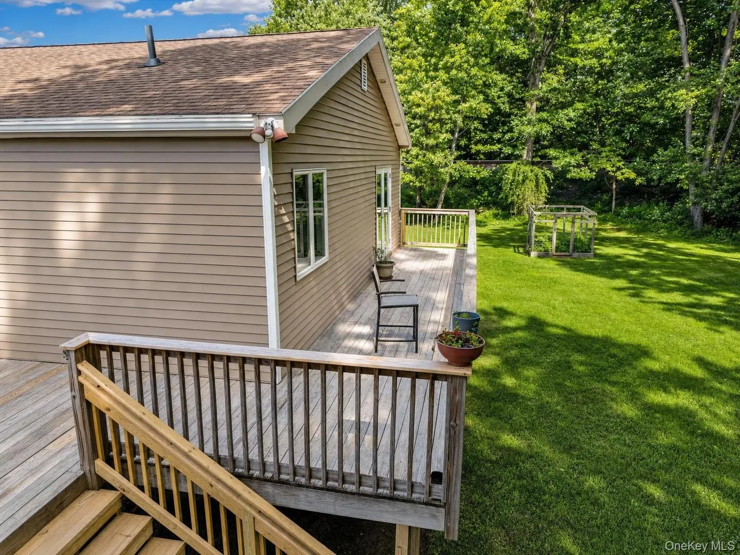 Spacious rear deck featuring natural wood decking and railings Spacious rear deck featuring natural wood decking and railings