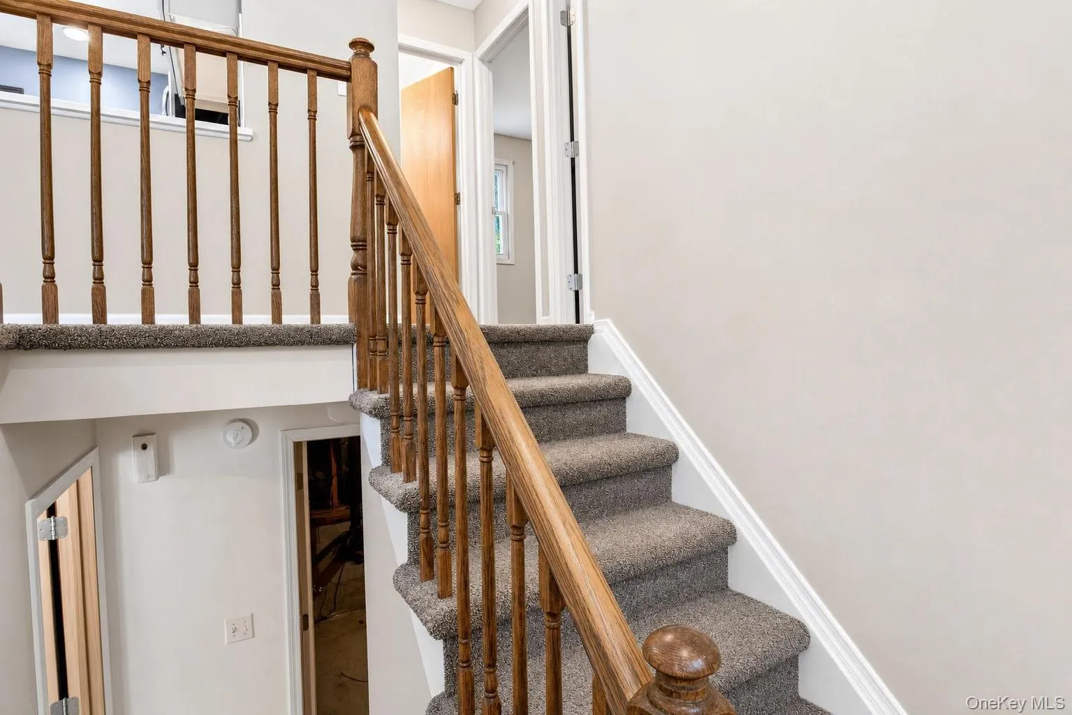 Carpeted staircase with wood-finish balusters and handrail Carpeted staircase with wood-finish balusters and handrail