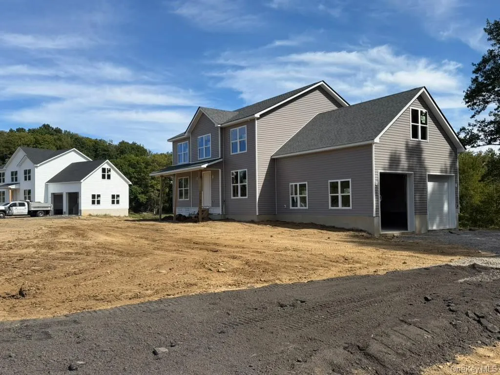 Newly constructed residence featuring gray horizontal siding and a dark shingle roof Newly constructed residence featuring gray horizontal siding and a dark shingle roof