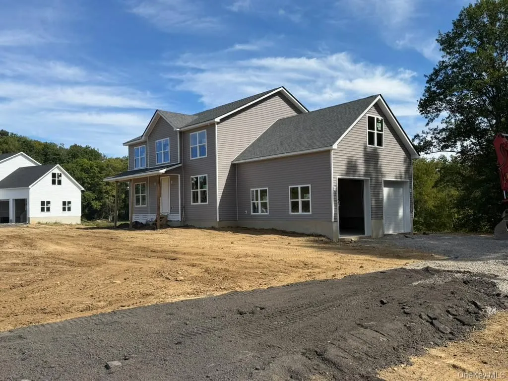 Newly constructed residence featuring gray siding and a dark shingle roof Newly constructed residence featuring gray siding and a dark shingle roof