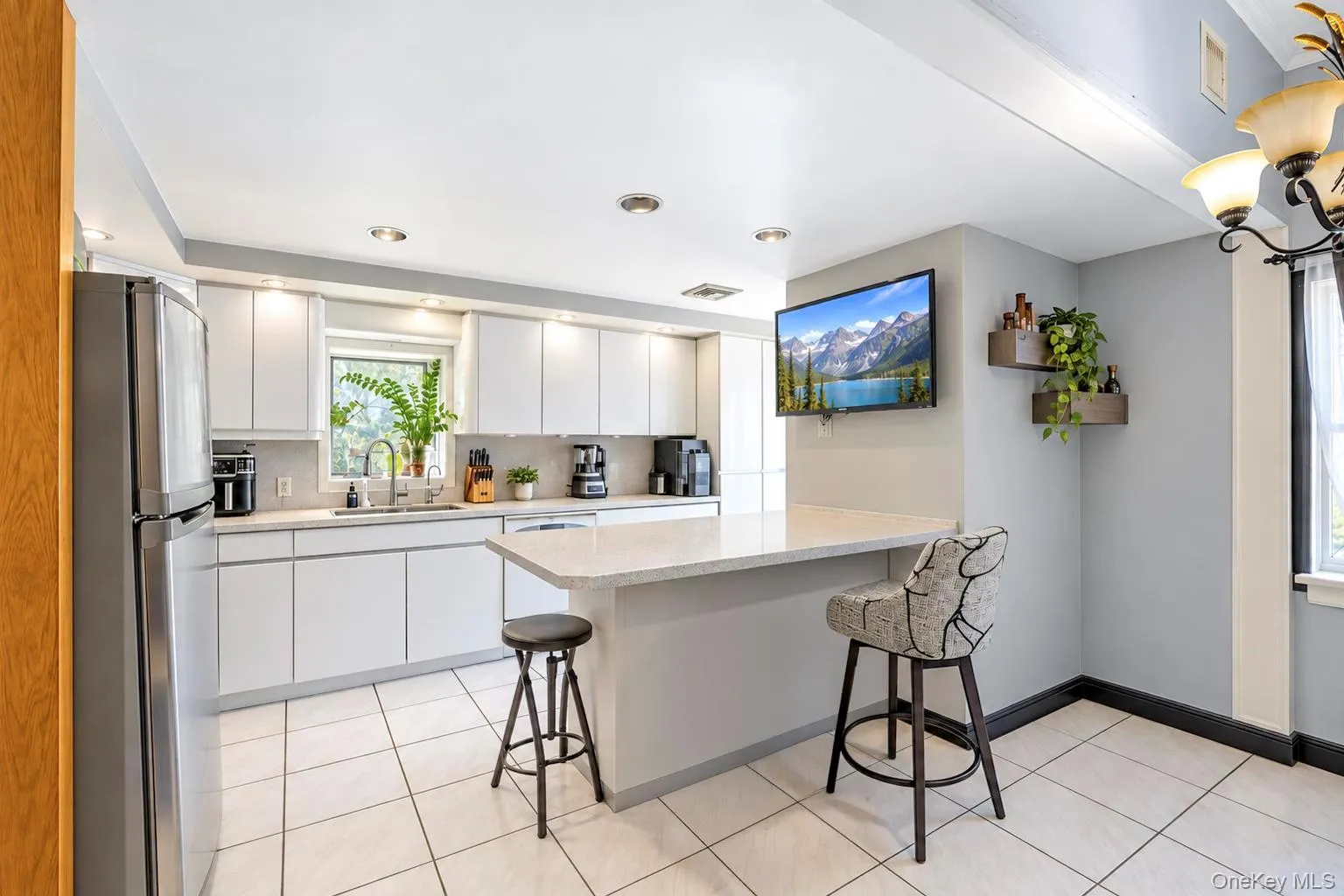 Modern kitchen featuring white cabinetry, a light-toned countertop, stainless steel appliances, and recessed lighting Modern kitchen featuring white cabinetry, a light-toned countertop, stainless steel appliances, and recessed lighting