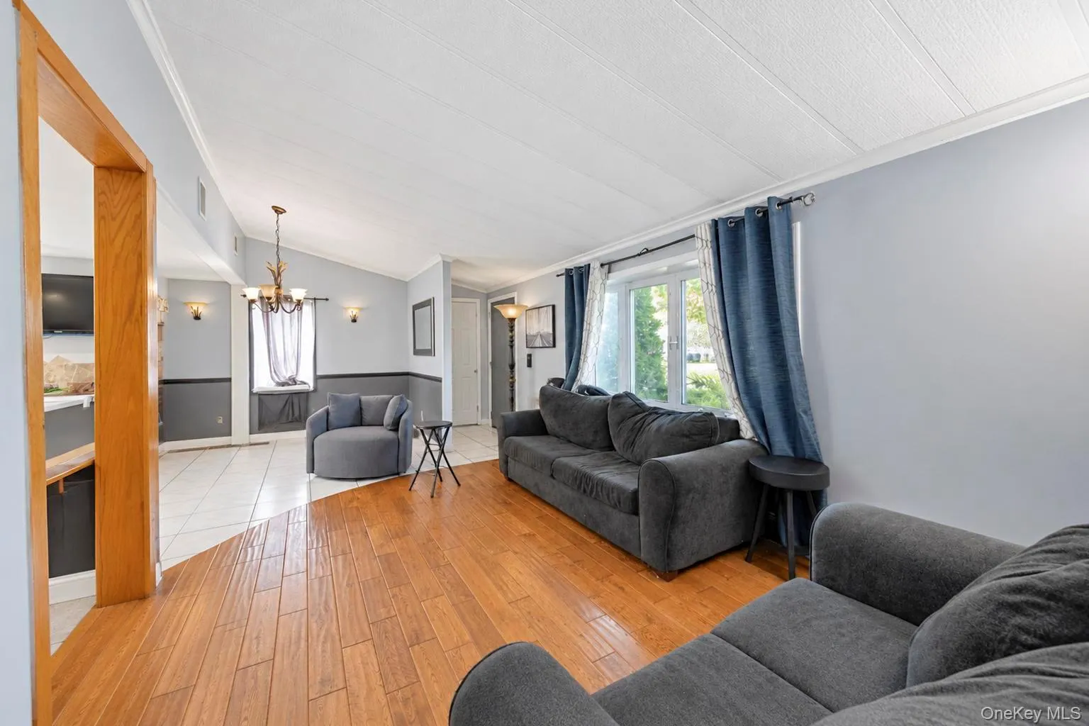 Hardwood flooring, tiled flooring, vaulted ceiling, built-in window seating, and a decorative chandelier Hardwood flooring, tiled flooring, vaulted ceiling, built-in window seating, and a decorative chandelier