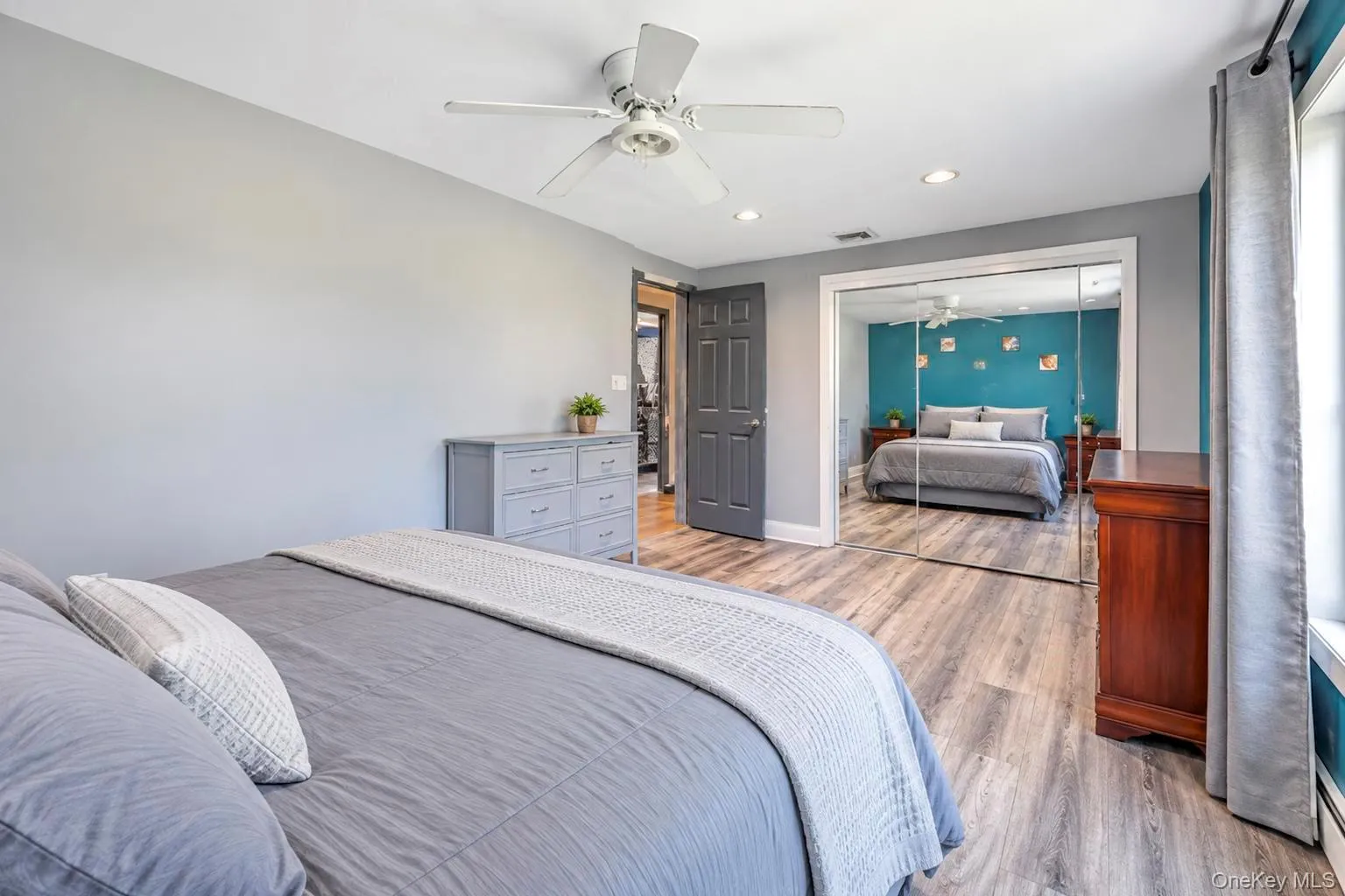 Wood-finish flooring, ceiling fan, recessed lighting, mirrored closet doors, and window with natural light Wood-finish flooring, ceiling fan, recessed lighting, mirrored closet doors, and window with natural light