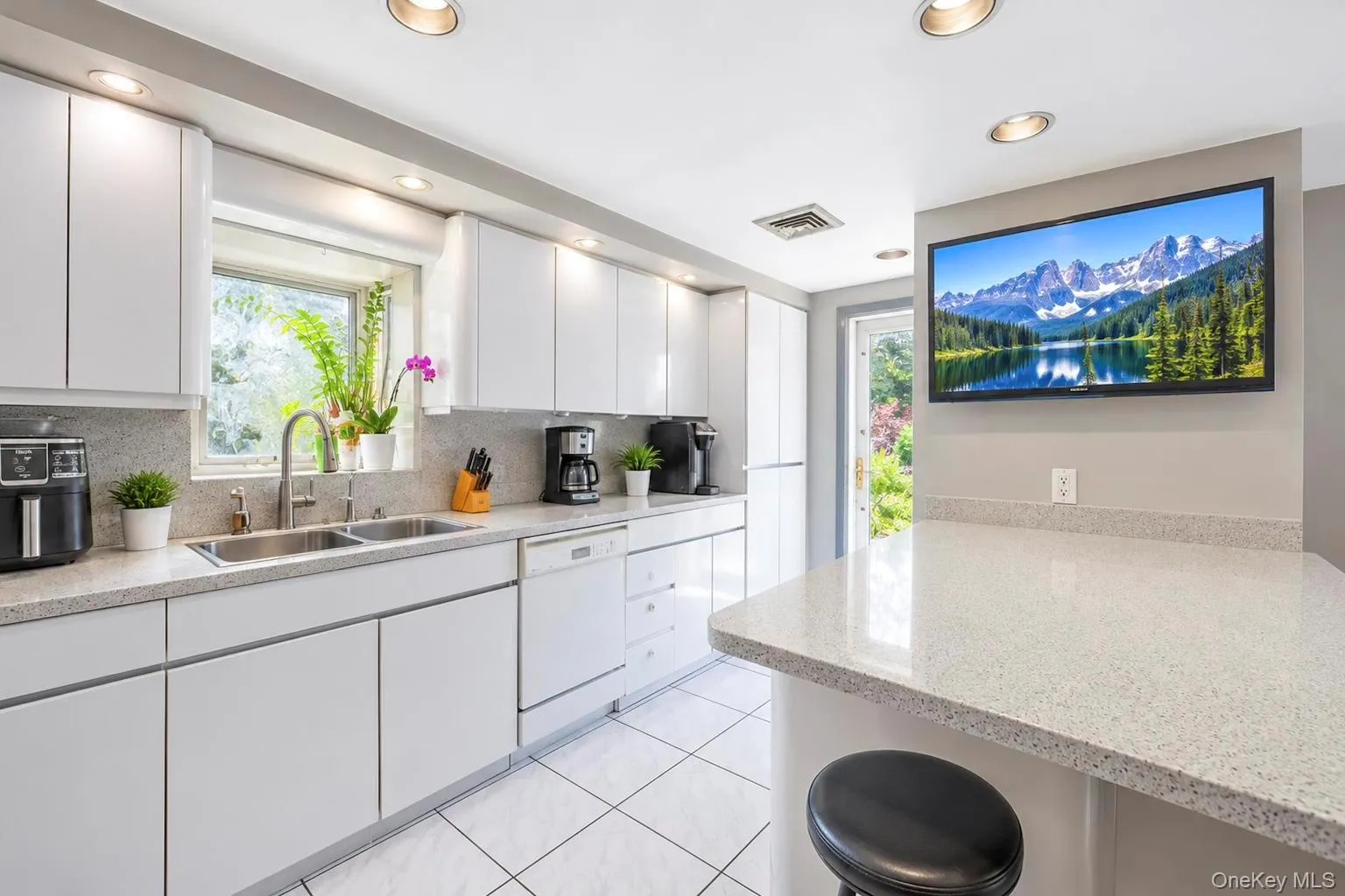 White cabinetry with recessed lighting, dual basin sink, and light-toned countertop White cabinetry with recessed lighting, dual basin sink, and light-toned countertop