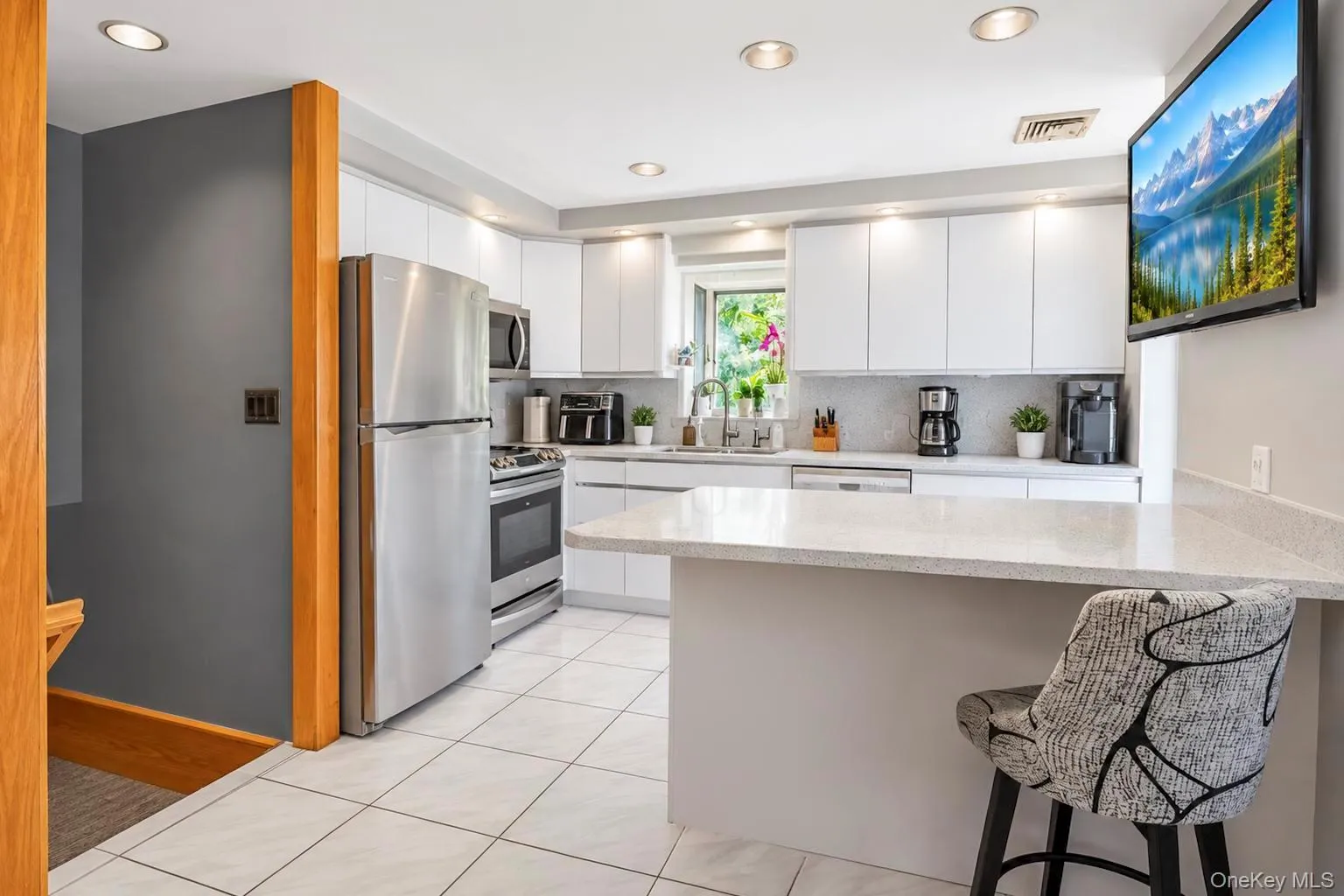 Kitchen featuring white cabinetry, stainless steel appliances, recessed lighting, a light-toned countertop, and tile flooring Kitchen featuring white cabinetry, stainless steel appliances, recessed lighting, a light-toned countertop, and tile flooring