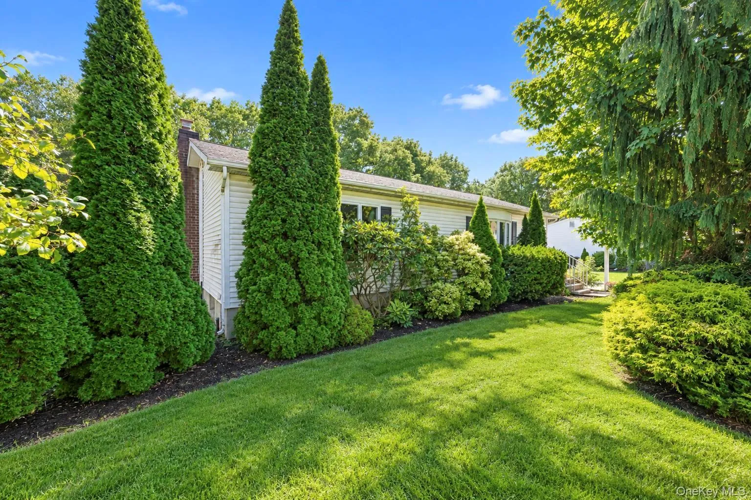 Expansive lawn with mature trees and established perimeter plantings Expansive lawn with mature trees and established perimeter plantings