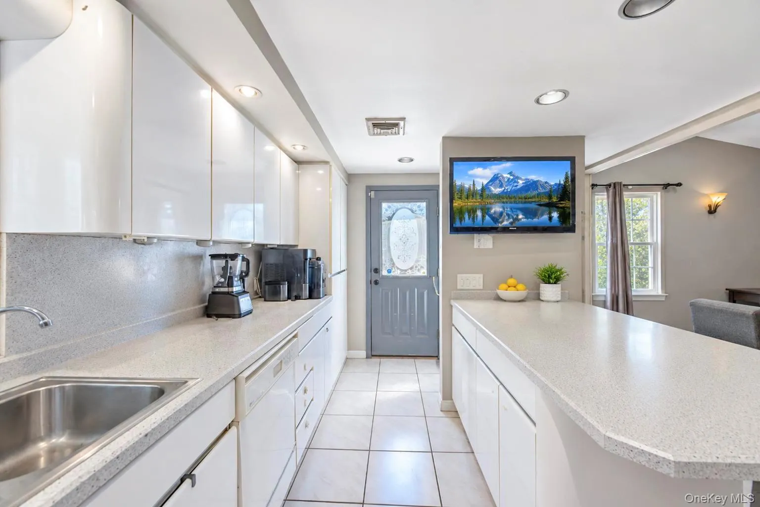 White cabinetry with a polished finish, light-toned countertops, and recessed ceiling lighting White cabinetry with a polished finish, light-toned countertops, and recessed ceiling lighting