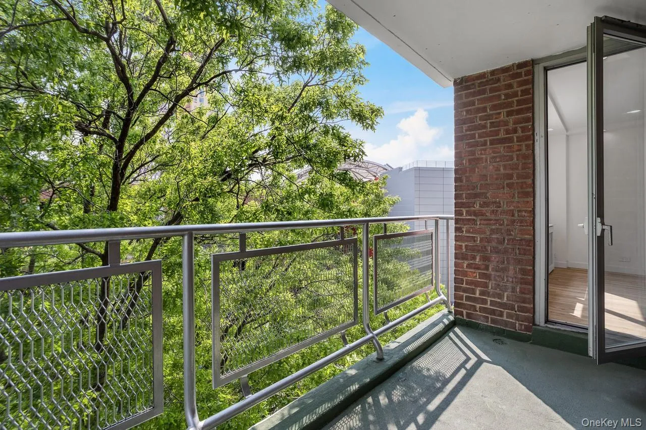 Private balcony featuring metal railing, brick exterior, and a glass-paneled door Private balcony featuring metal railing, brick exterior, and a glass-paneled door