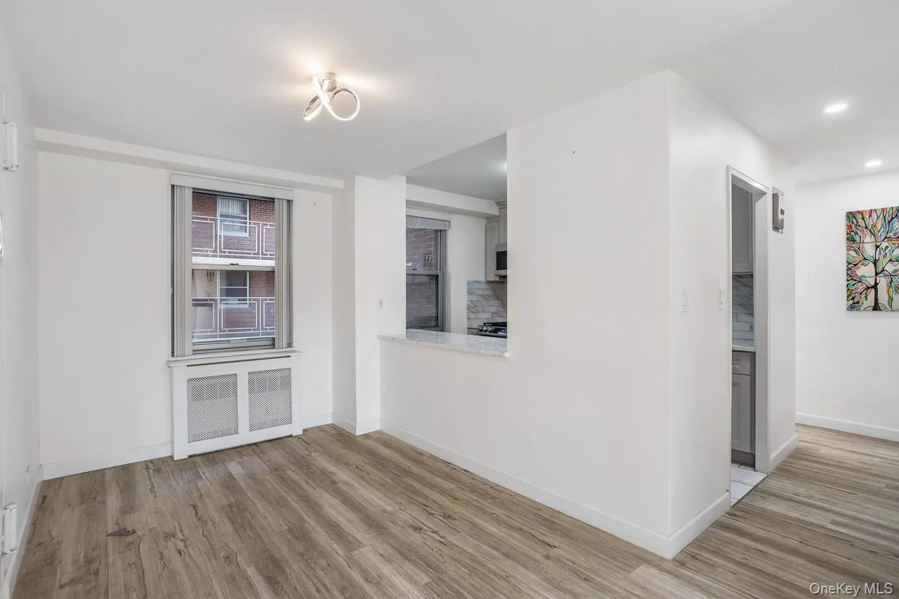 Wood-finish flooring, recessed lighting, and a modern ceiling fixture Wood-finish flooring, recessed lighting, and a modern ceiling fixture