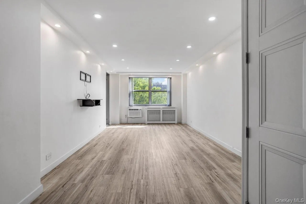 Recessed lighting throughout, wood-finish flooring, light-colored walls, window with exterior view, panel door Recessed lighting throughout, wood-finish flooring, light-colored walls, window with exterior view, panel door