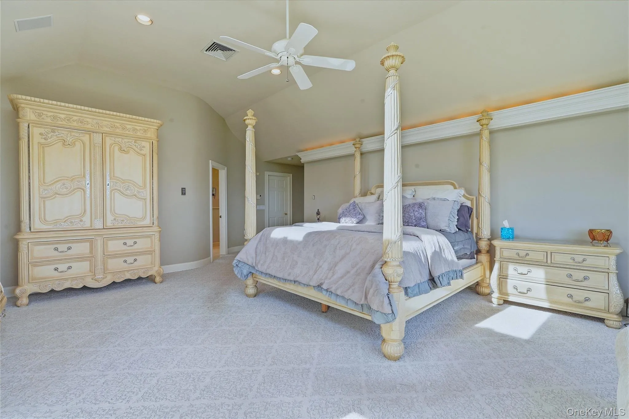 Vaulted ceiling with a ceiling fan, recessed lighting, complemented by carpet flooring Vaulted ceiling with a ceiling fan, recessed lighting, complemented by carpet flooring