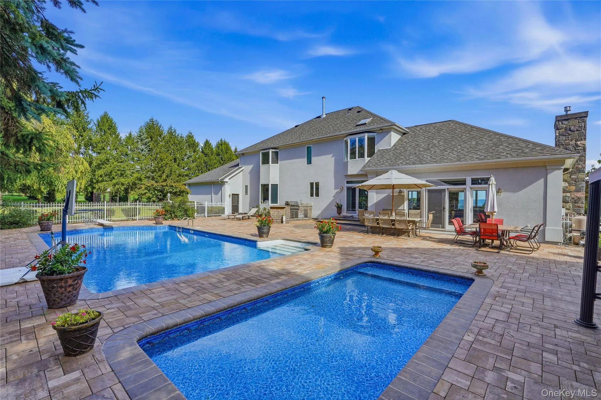 Expansive paver patio with a rectangular pool and an additional plunge pool Expansive paver patio with a rectangular pool and an additional plunge pool