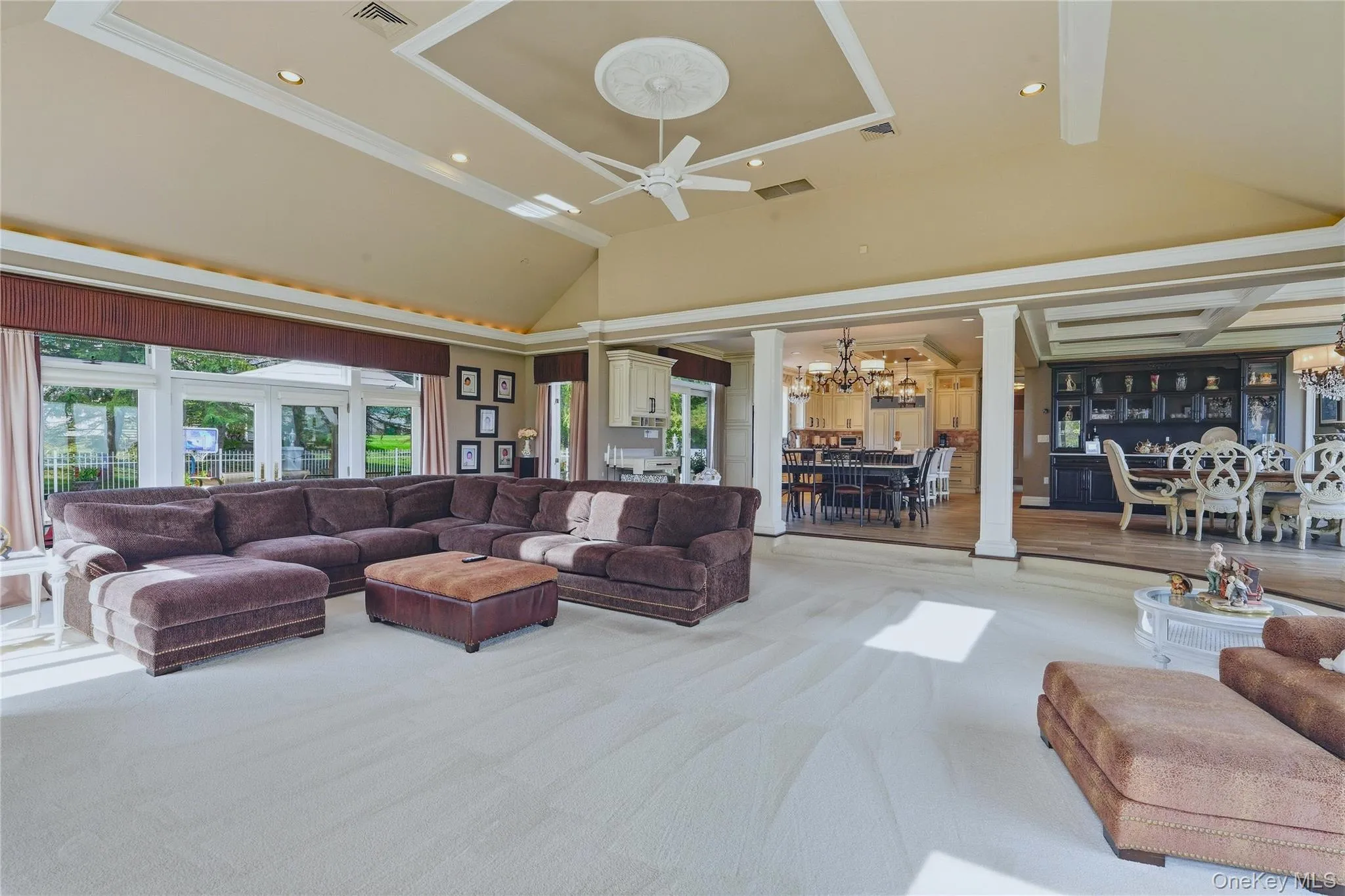 Vaulted ceiling with recessed lighting, large windows, tray ceiling with medallion, ceiling fan, and built-in cabinetry Vaulted ceiling with recessed lighting, large windows, tray ceiling with medallion, ceiling fan, and built-in cabinetry