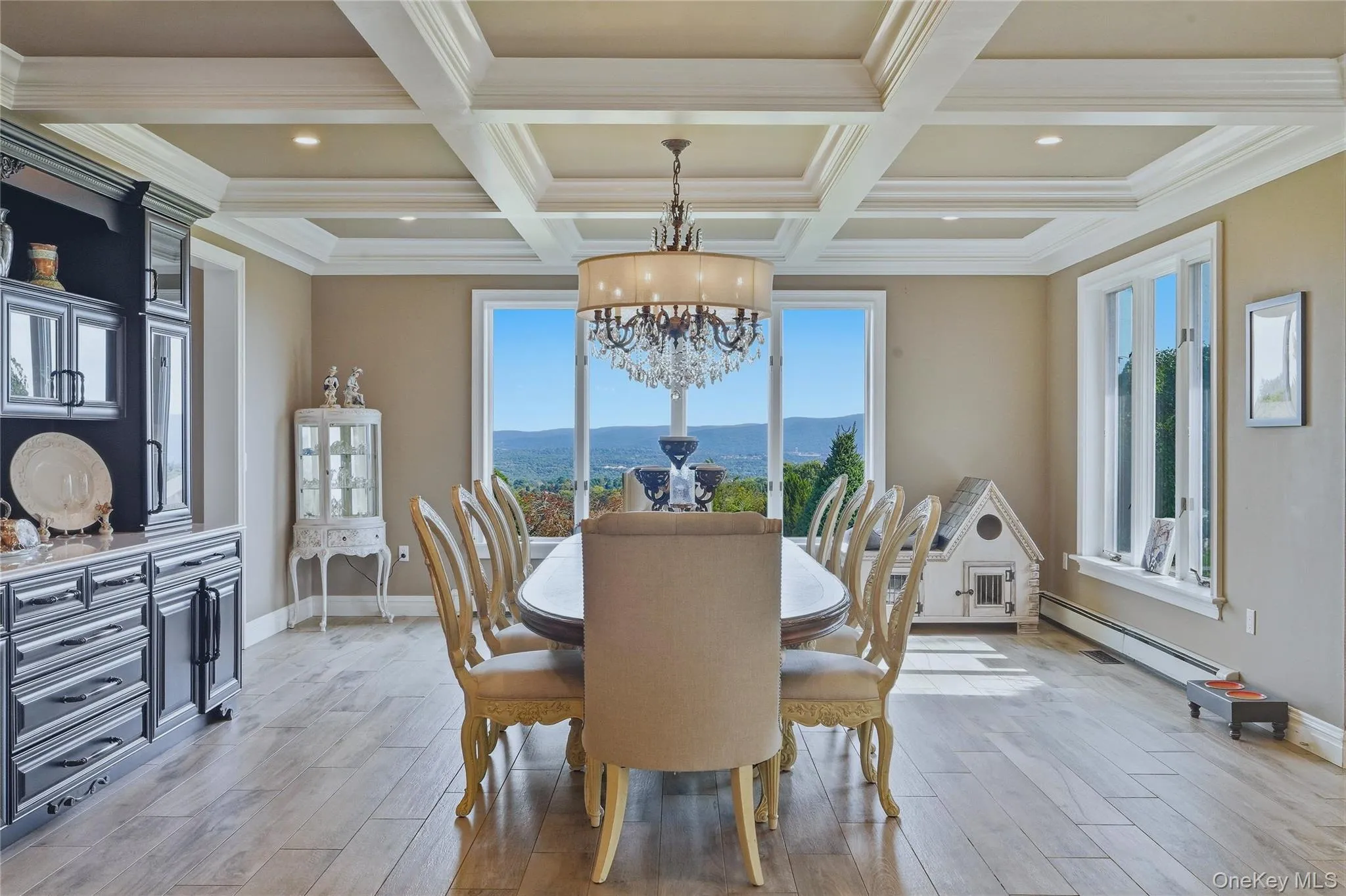 Coffered ceiling with recessed lighting, built-in cabinetry, large windows, mountain views and a chandelier Coffered ceiling with recessed lighting, built-in cabinetry, large windows, mountain views and a chandelier