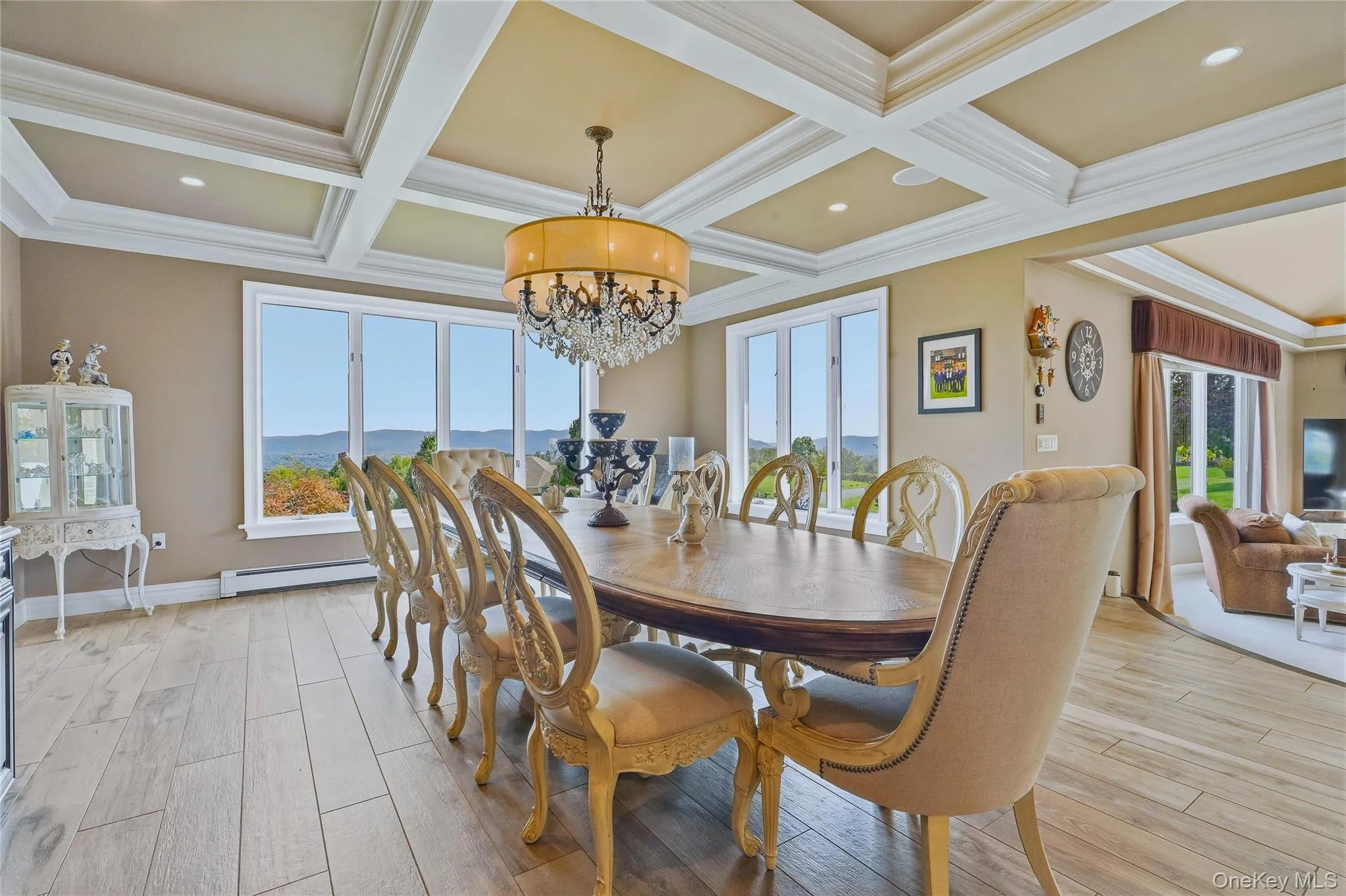 Coffer-style ceiling with recessed lighting, large picture windows, and a chandelier Coffer-style ceiling with recessed lighting, large picture windows, and a chandelier
