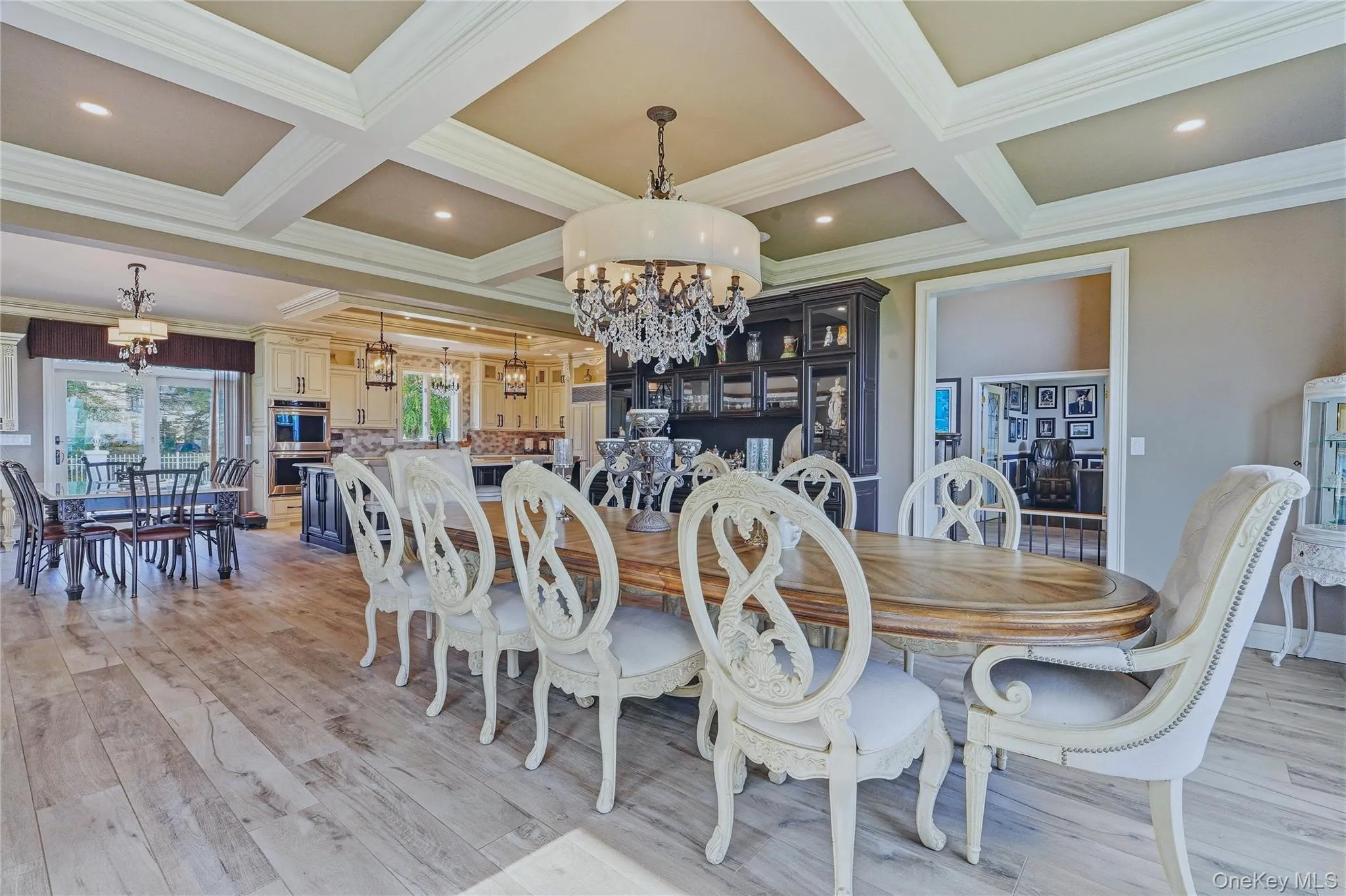 Coffered ceiling, chandelier lighting, built-in display cabinetry, and sliding glass door Coffered ceiling, chandelier lighting, built-in display cabinetry, and sliding glass door