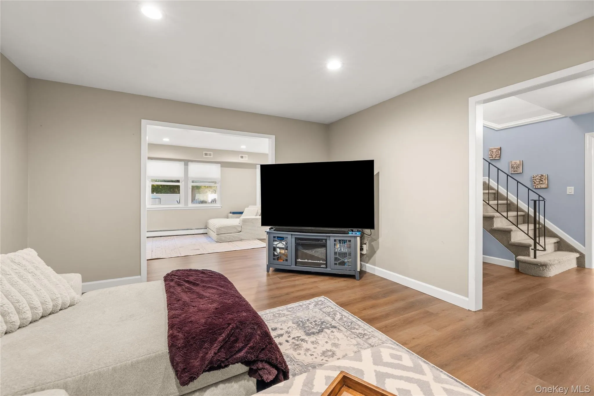 Living room. Recessed lighting illuminates the wood-finish flooring Living room. Recessed lighting illuminates the wood-finish flooring