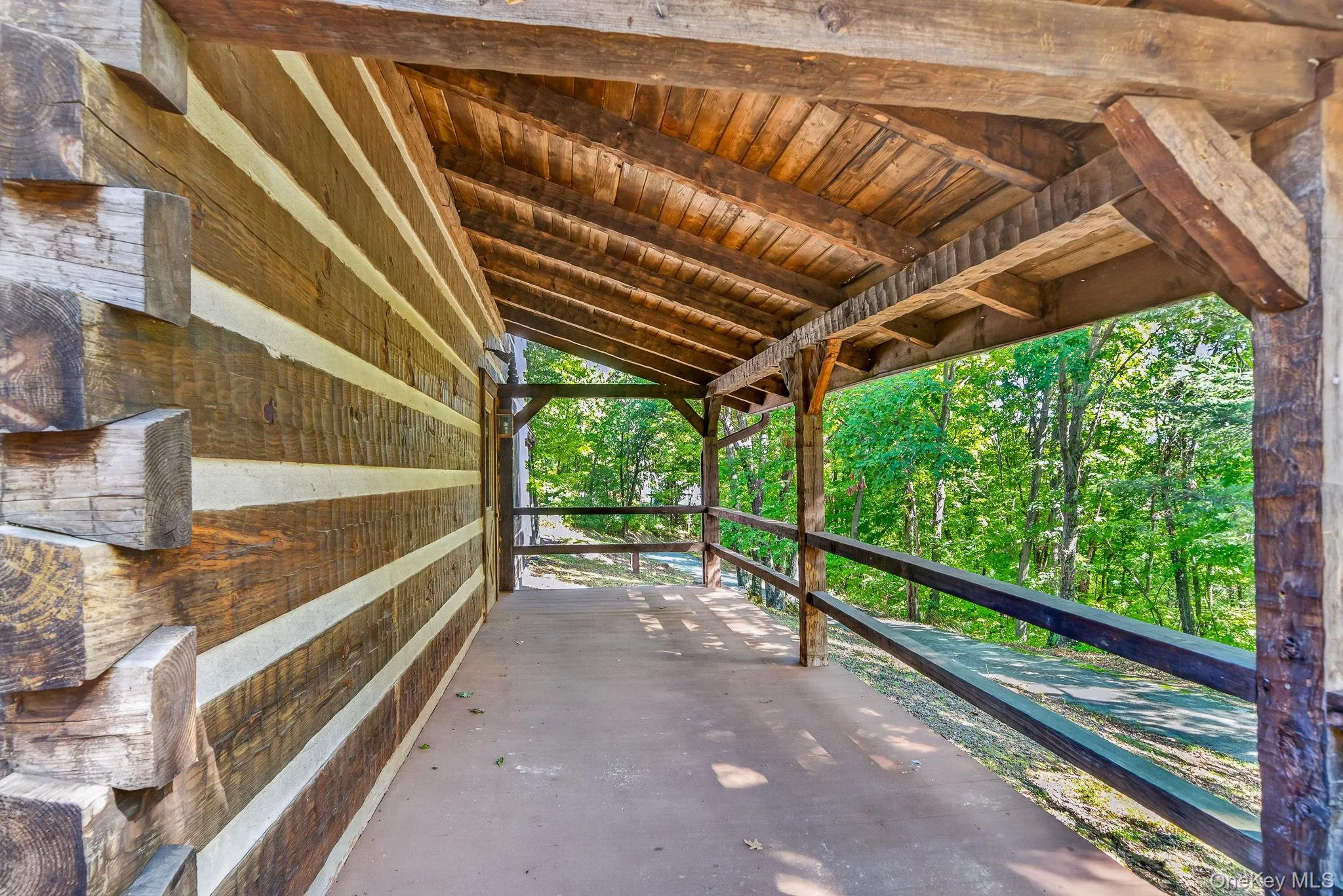Front porch looking to driveway. Classic dovetail notched corners. Hand-hewn beams. Front porch looking to driveway. Classic dovetail notched corners. Hand-hewn beams.