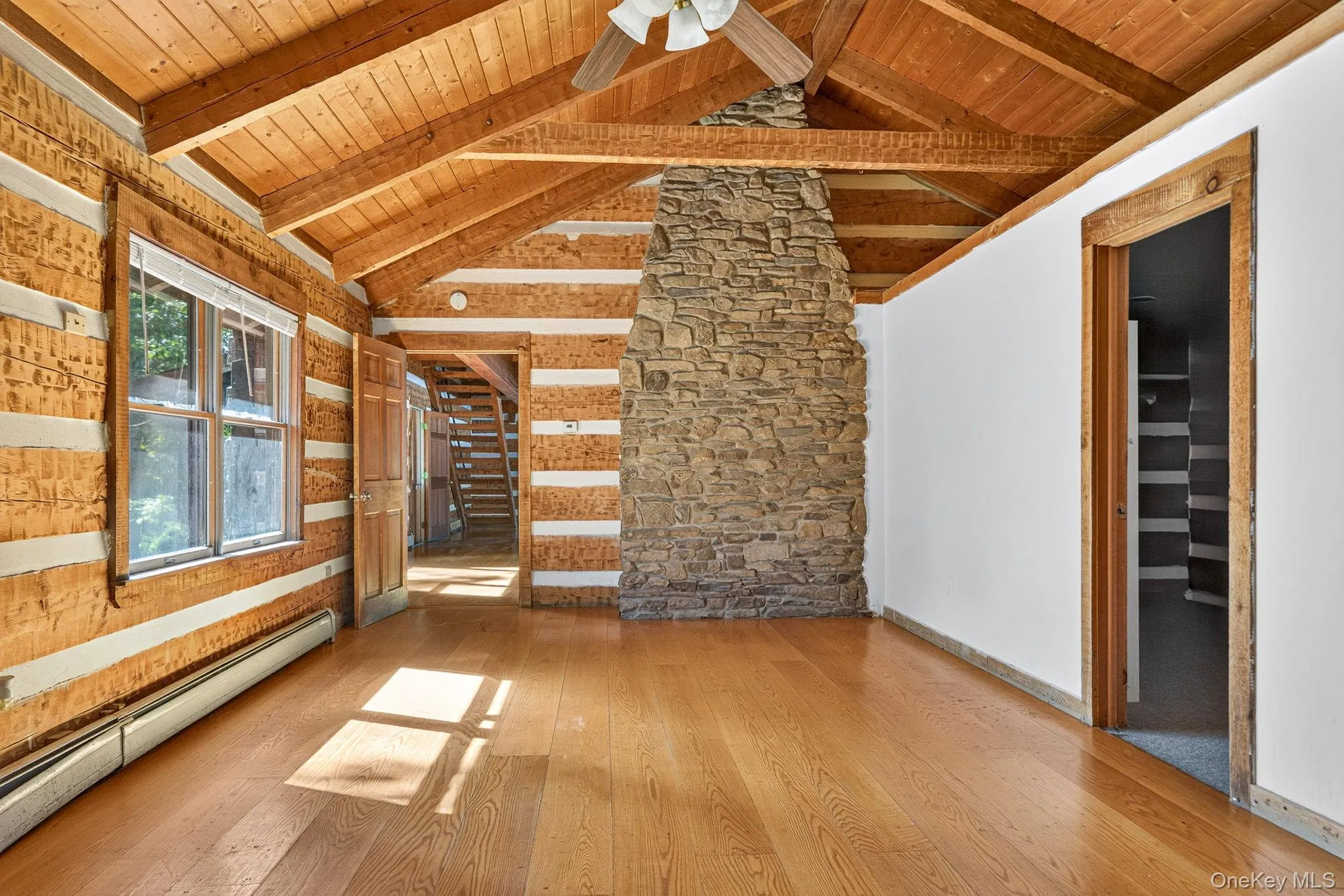 Main residence primary bedroom featuring back of family room stone fireplace. IGenerous walk-in closet and full bathroom. Main residence primary bedroom featuring back of family room stone fireplace. IGenerous walk-in closet and full bathroom.