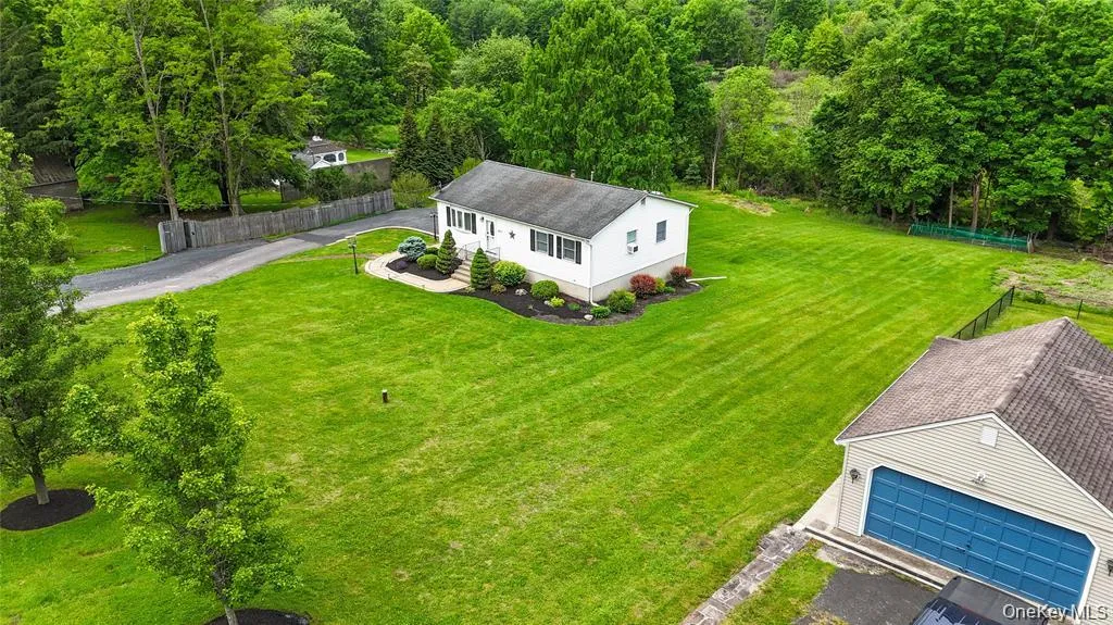 White ranch-style residence with a dark roof and foundation planting White ranch-style residence with a dark roof and foundation planting
