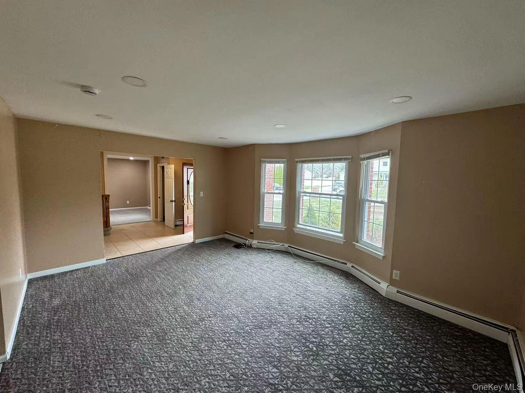 Spare room featuring baseboards and carpet floors Spare room featuring baseboards and carpet floors