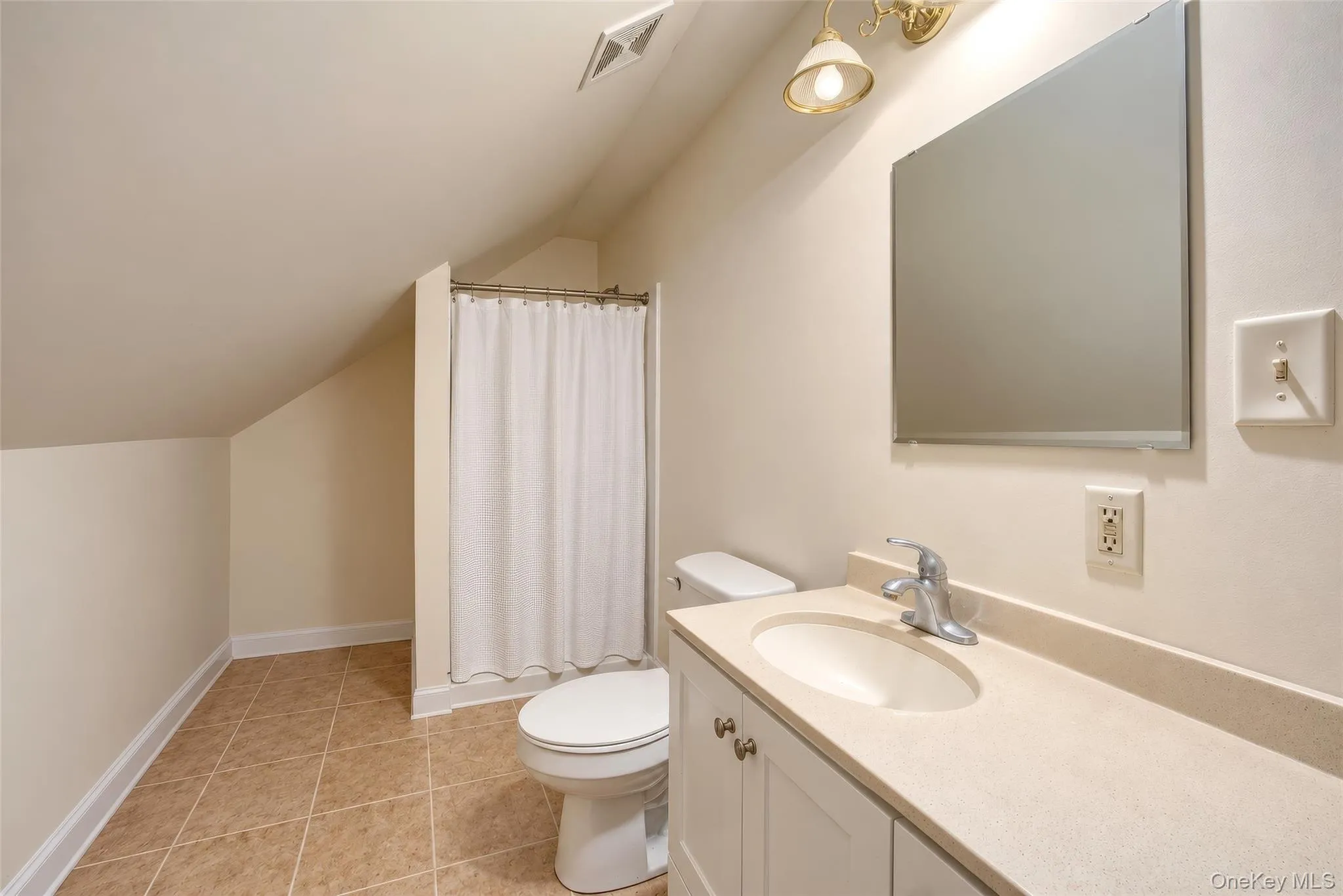 Bathroom featuring tile flooring, single vanity with integrated sink, wall-mounted mirror, and a shower area Bathroom featuring tile flooring, single vanity with integrated sink, wall-mounted mirror, and a shower area