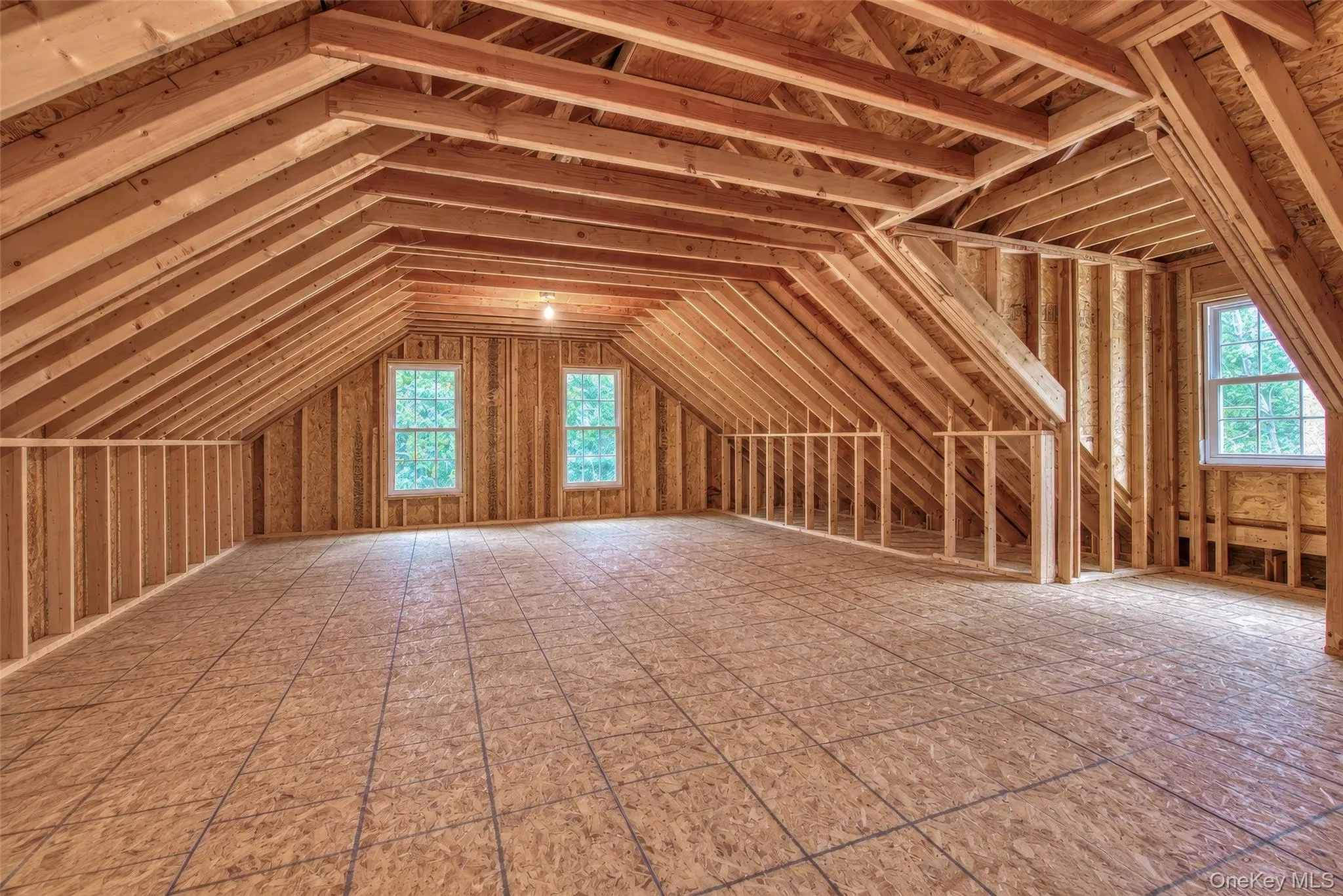 Expansive unfinished 2nd floor area featuring exposed wood framing, wood subflooring, and multiple windows Expansive unfinished 2nd floor area featuring exposed wood framing, wood subflooring, and multiple windows