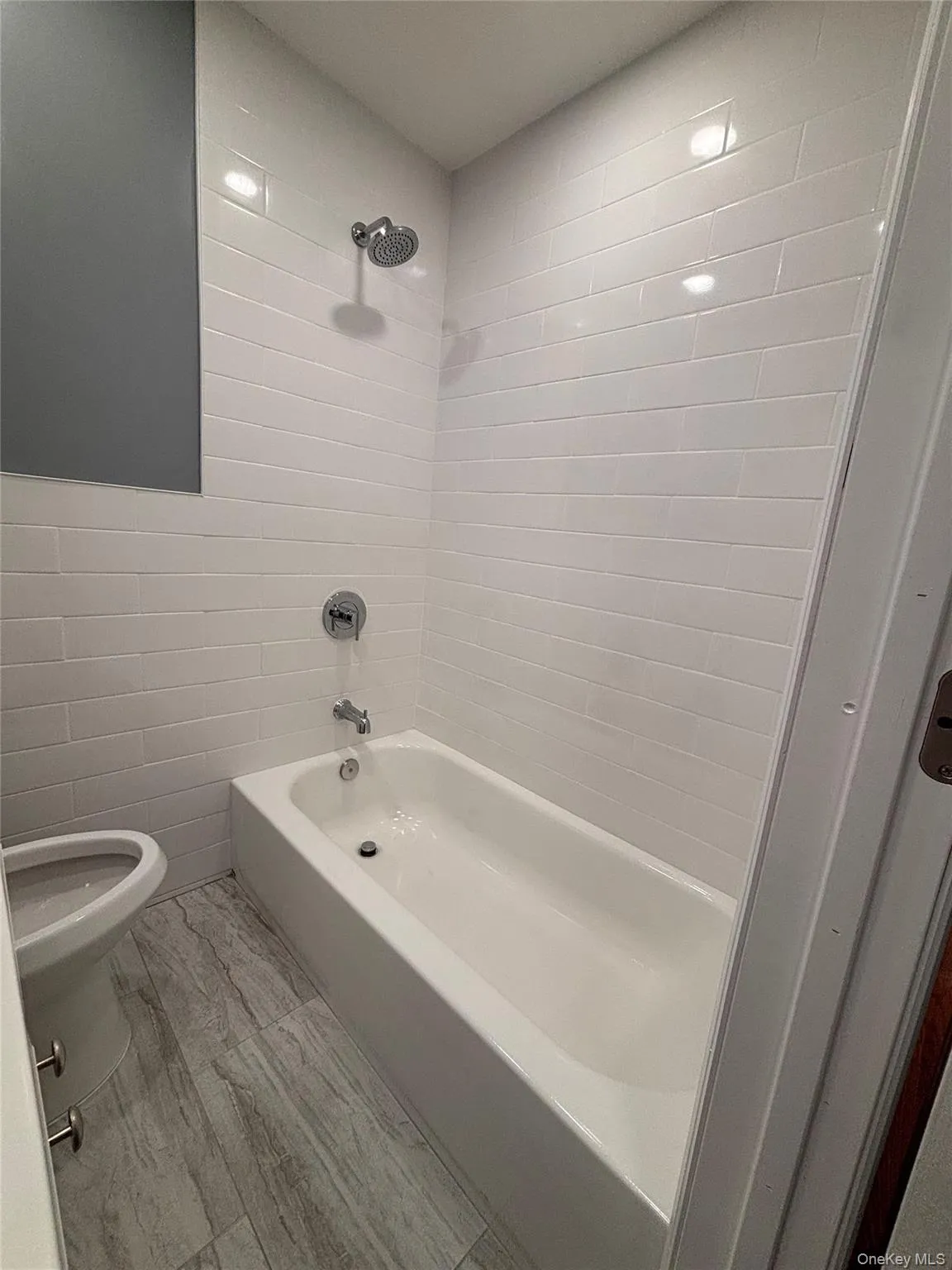 White subway tile shower surround with a built-in tub and chrome fixtures White subway tile shower surround with a built-in tub and chrome fixtures
