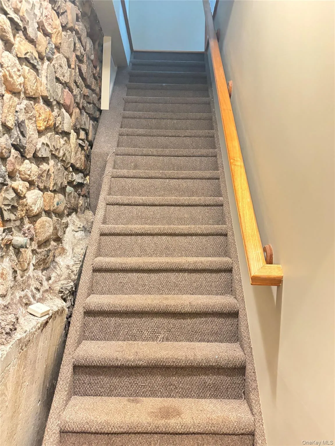 From the garage up to the first floor take the staircase which has original features of the home, including a stone-clad wall From the garage up to the first floor take the staircase which has original features of the home, including a stone-clad wall