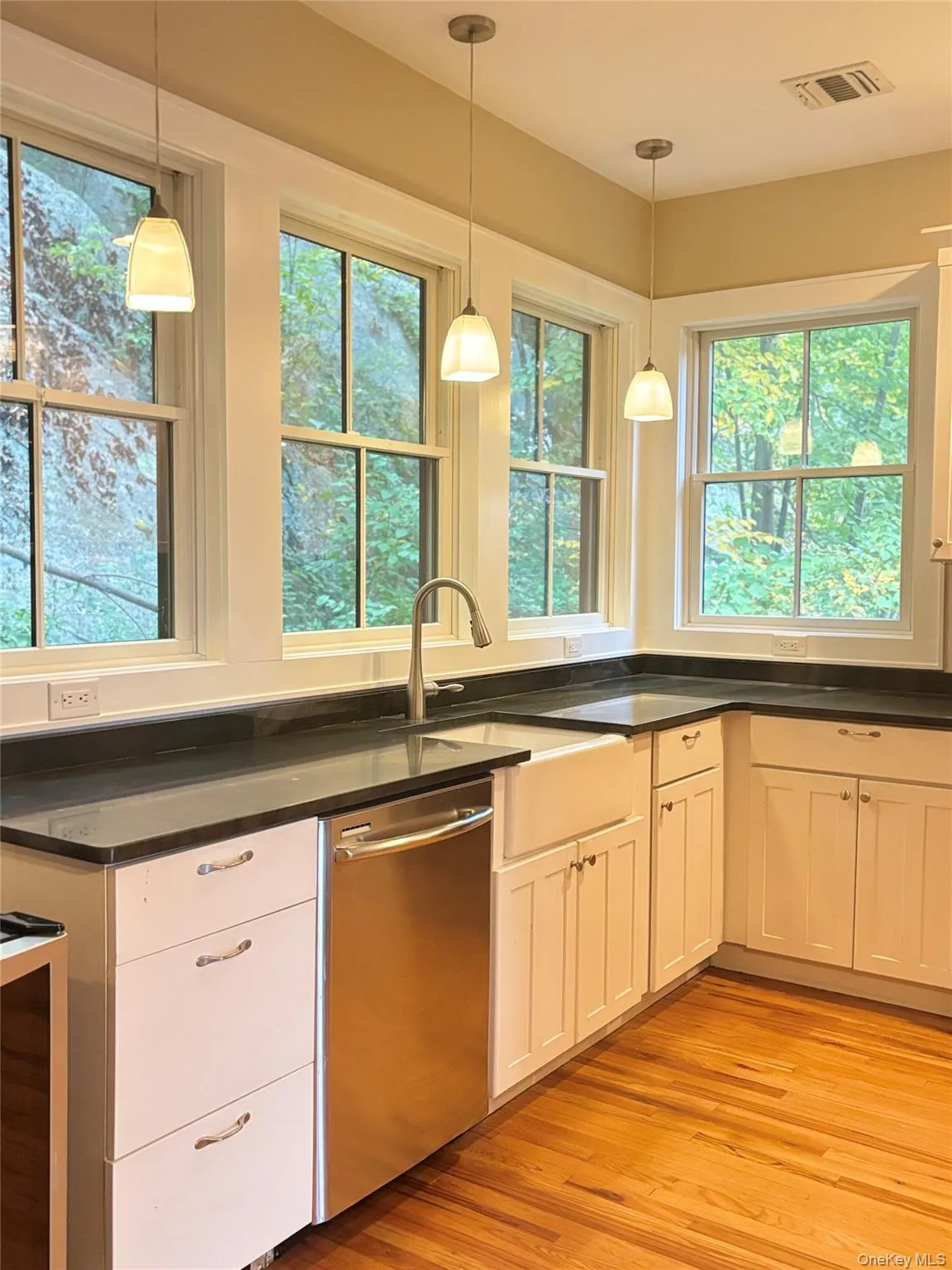The open concept kitchen has hardwood flooring throughout custom lighting, as well as recessed lighting. The open concept kitchen has hardwood flooring throughout custom lighting, as well as recessed lighting.